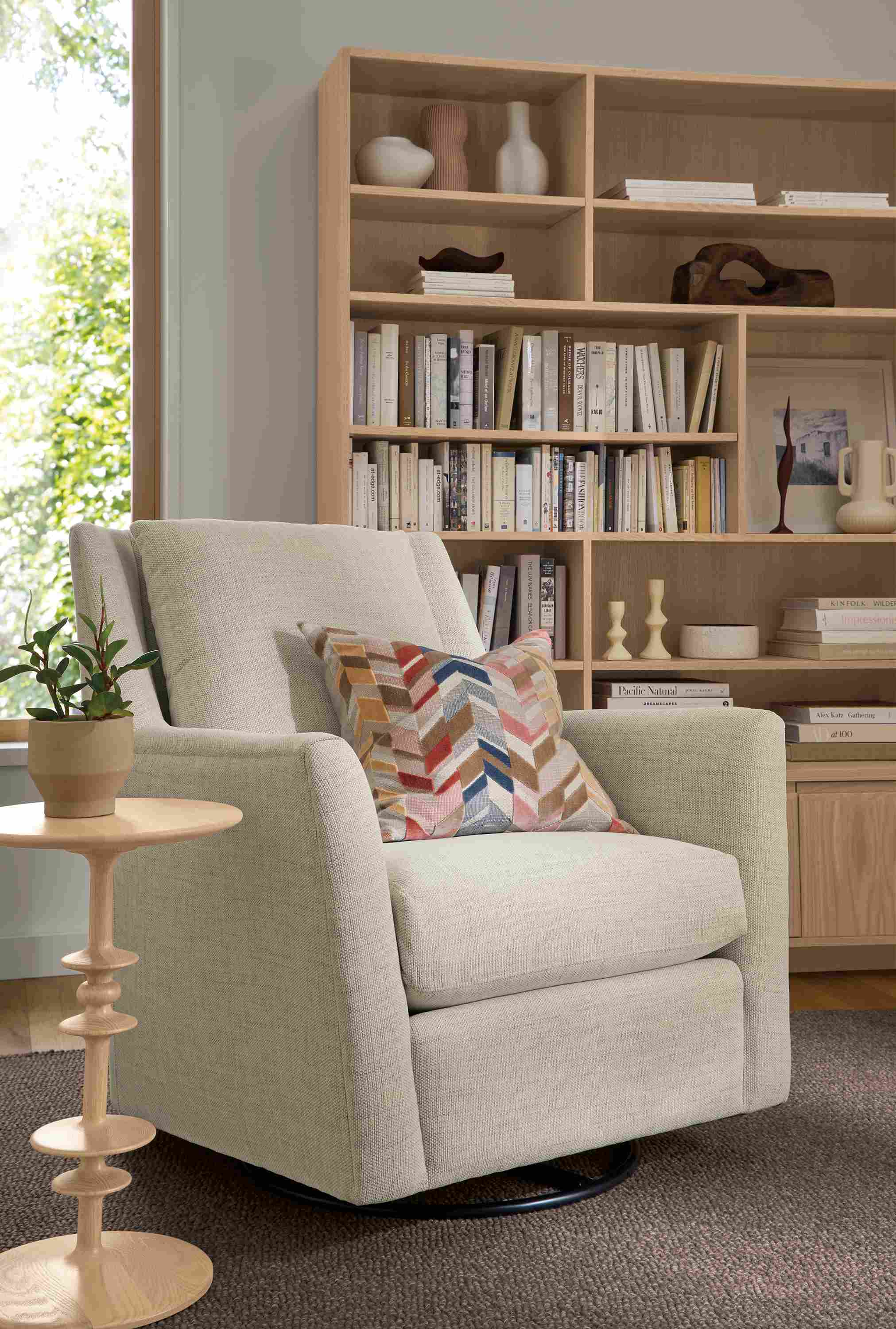 Living room with Kennedy swivel glider in Olmstead Natural and Parks round end table in salt on red oak.