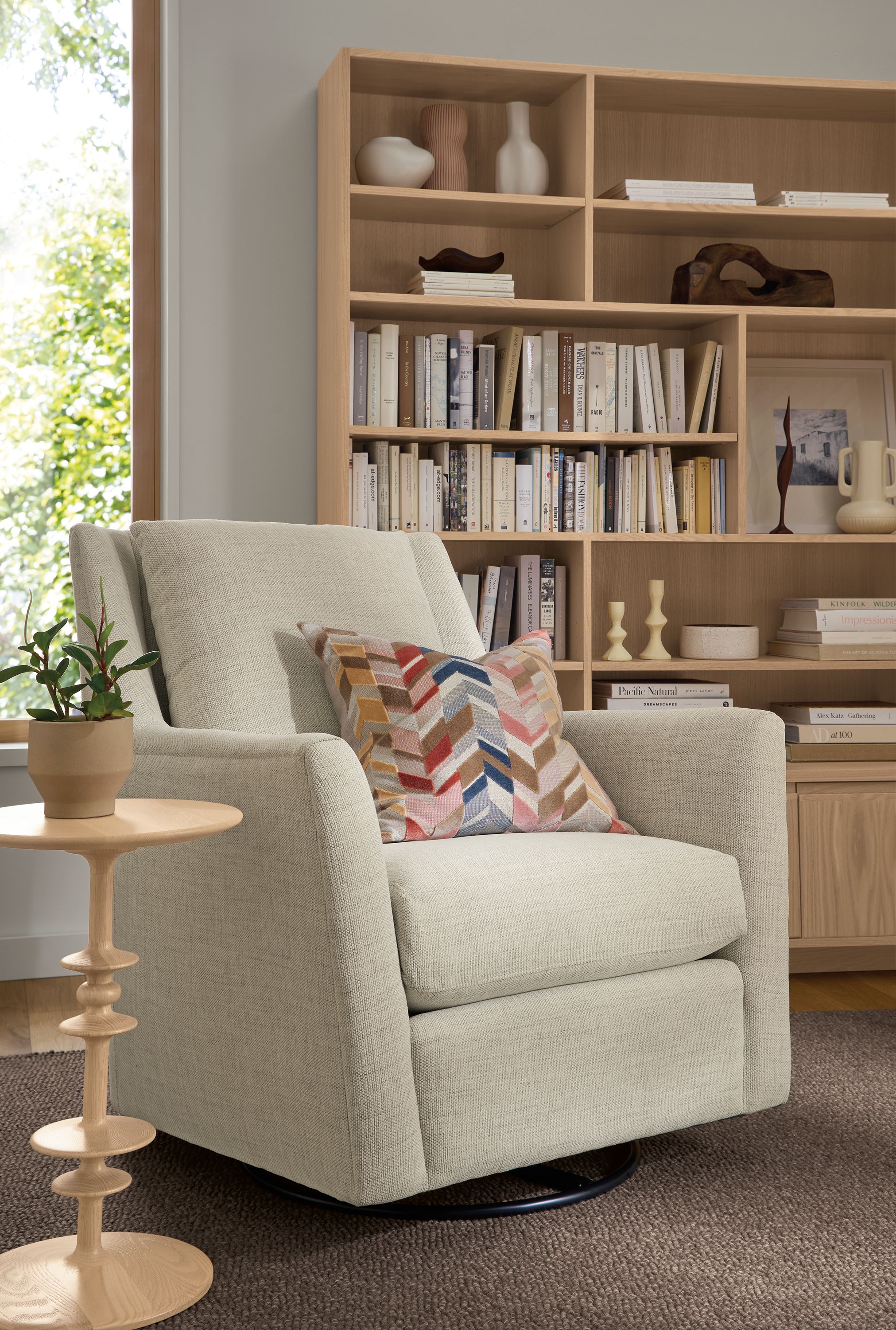 Living room with Kennedy swivel glider in Olmstead Natural and Parks round end table in salt on red oak.