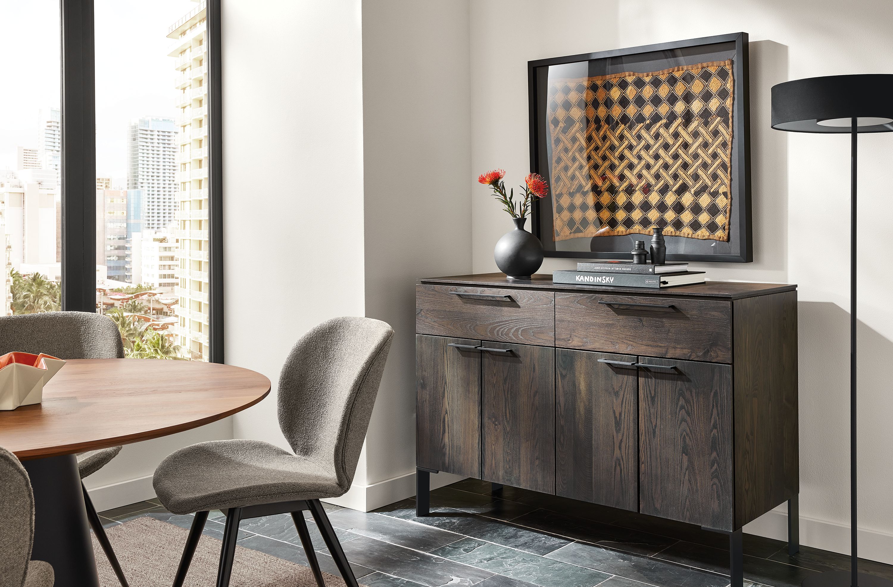 Dining area with Kenwood 50-wide storage cabinet in charcoal, Decker round table and Gwen side chairs in Radford taupe.