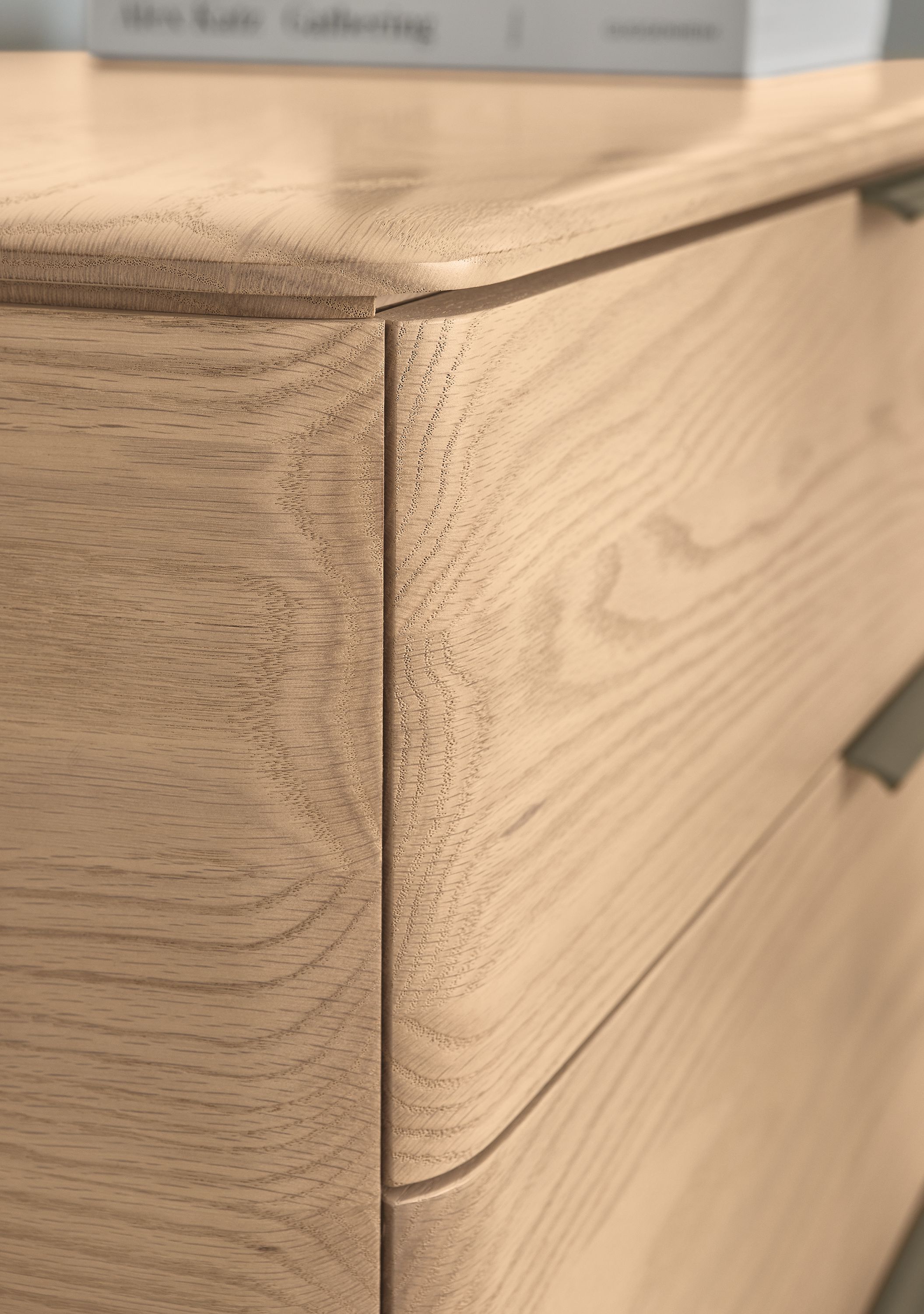 Detail shot of drawer corner on a Kingston 6-drawer dresser in salt on red oak.