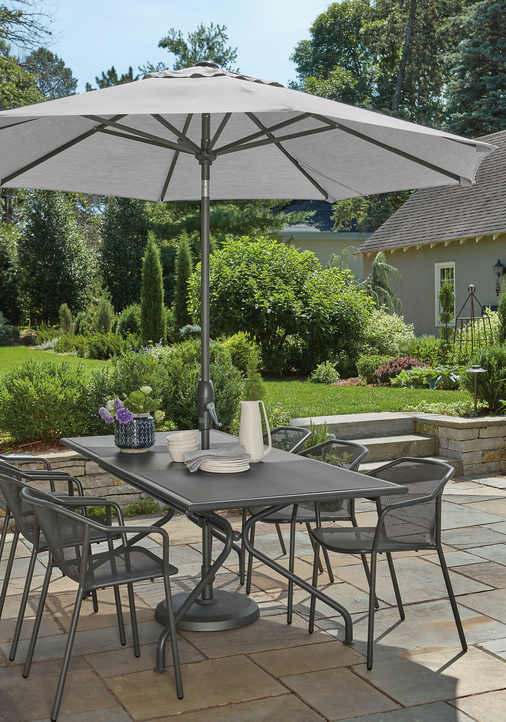 Outdoor patio with Kona extension table and six theo chairs in graphite.