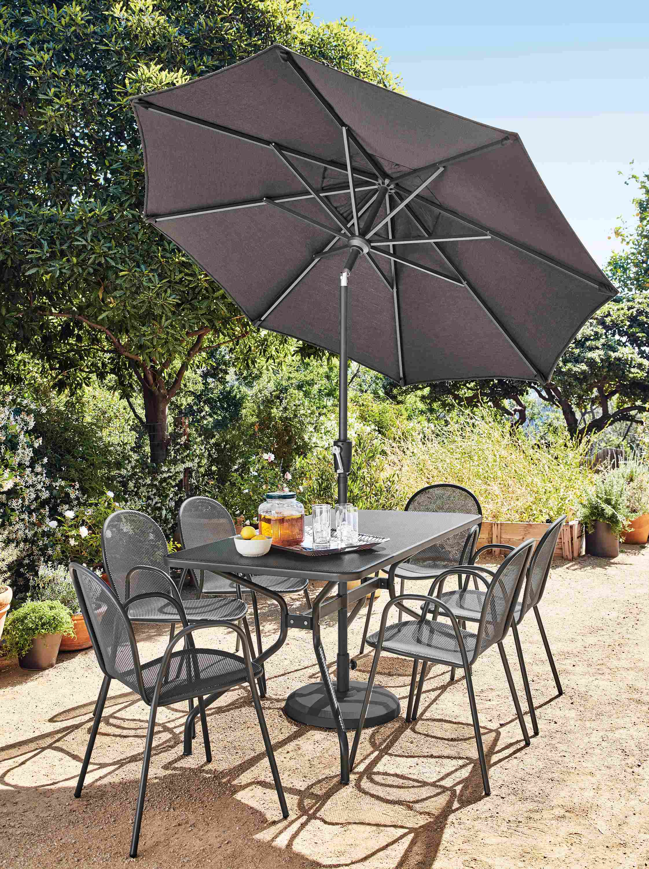 Patio with Kona table in graphite, 6 Rio chairs in graphite and Maui umbrella with base in Tavros charcoal.