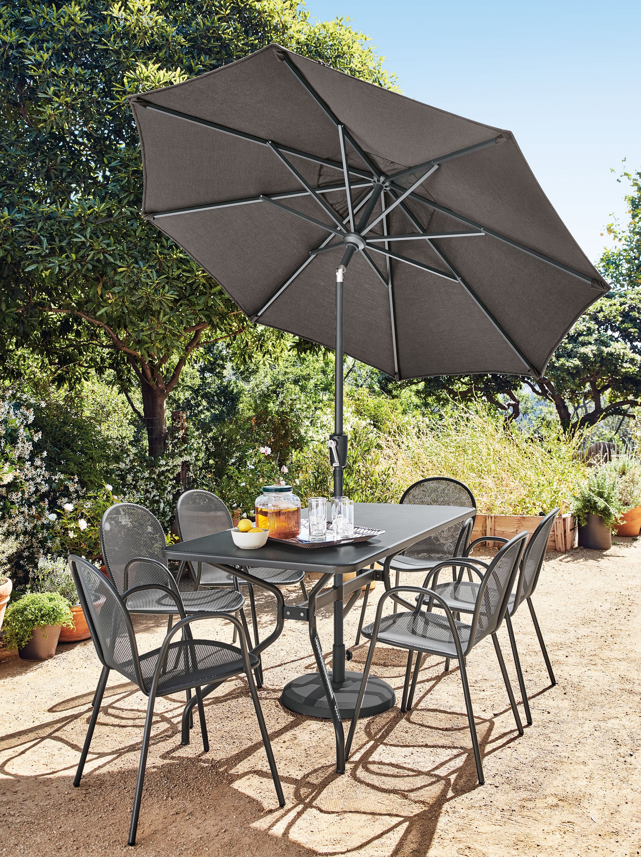 Patio with Kona table in graphite, 6 Rio chairs in graphite and Maui umbrella with base in Tavros charcoal.