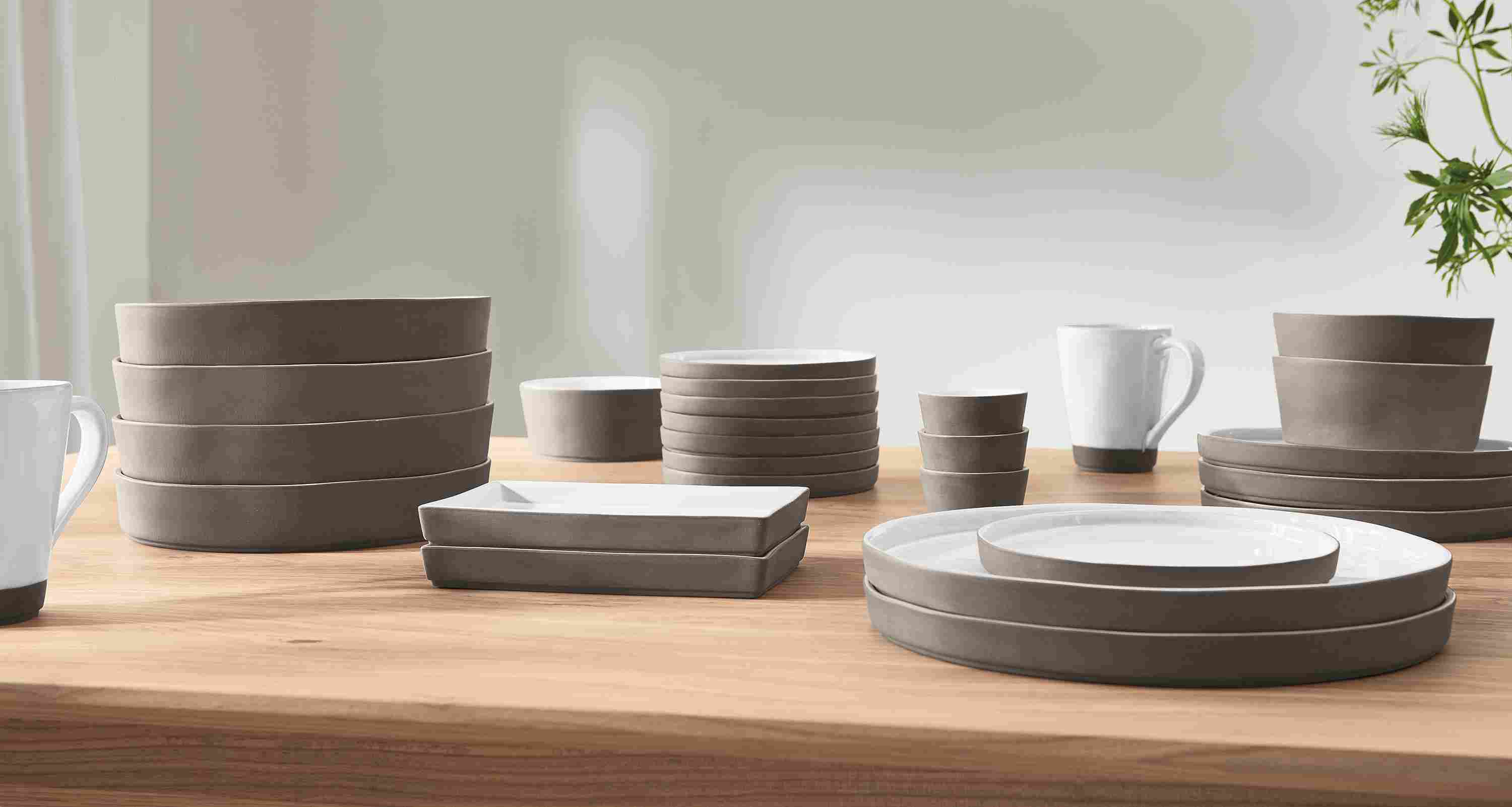 detail of stacked Lagoa dinner plates, bowls and cups on tabletop.