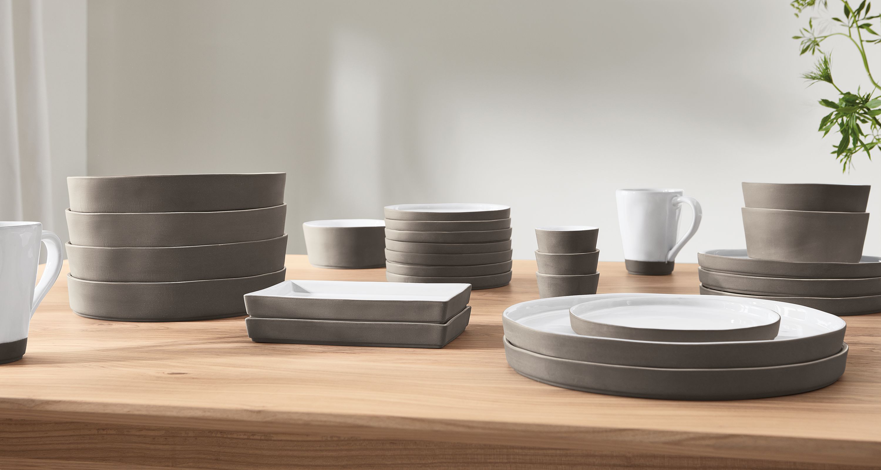 detail of stacked Lagoa dinner plates, bowls and cups on tabletop.