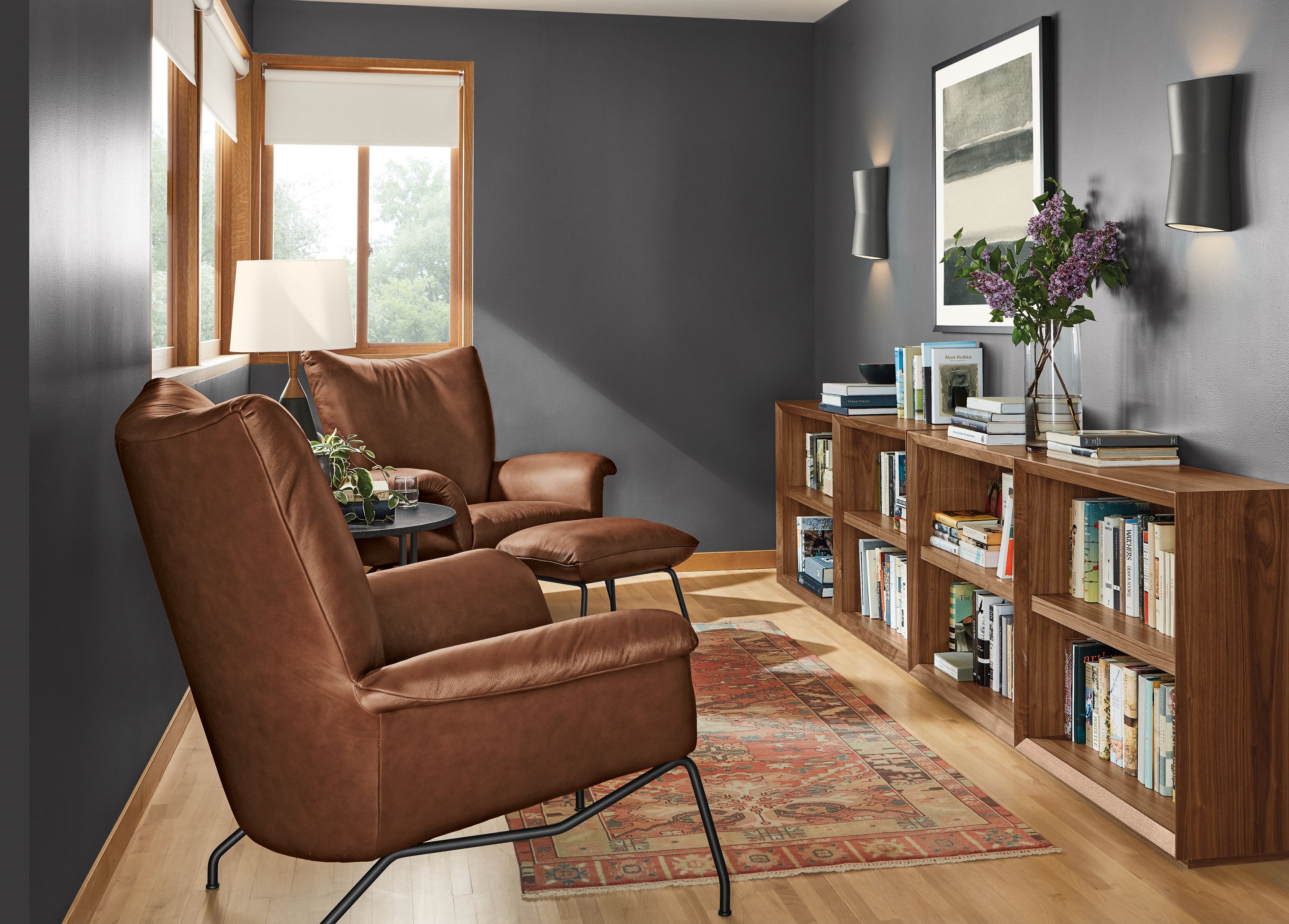 Detail of Lennox bookcase in living room with two Paris chairs in lecco leather.