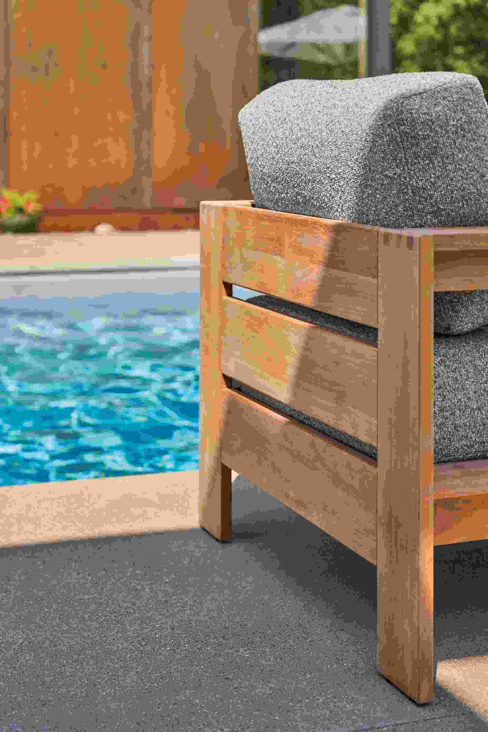 Poolside detail of backside of Leti Lounge chair in teak heartwood with Kloss Otter fabric.