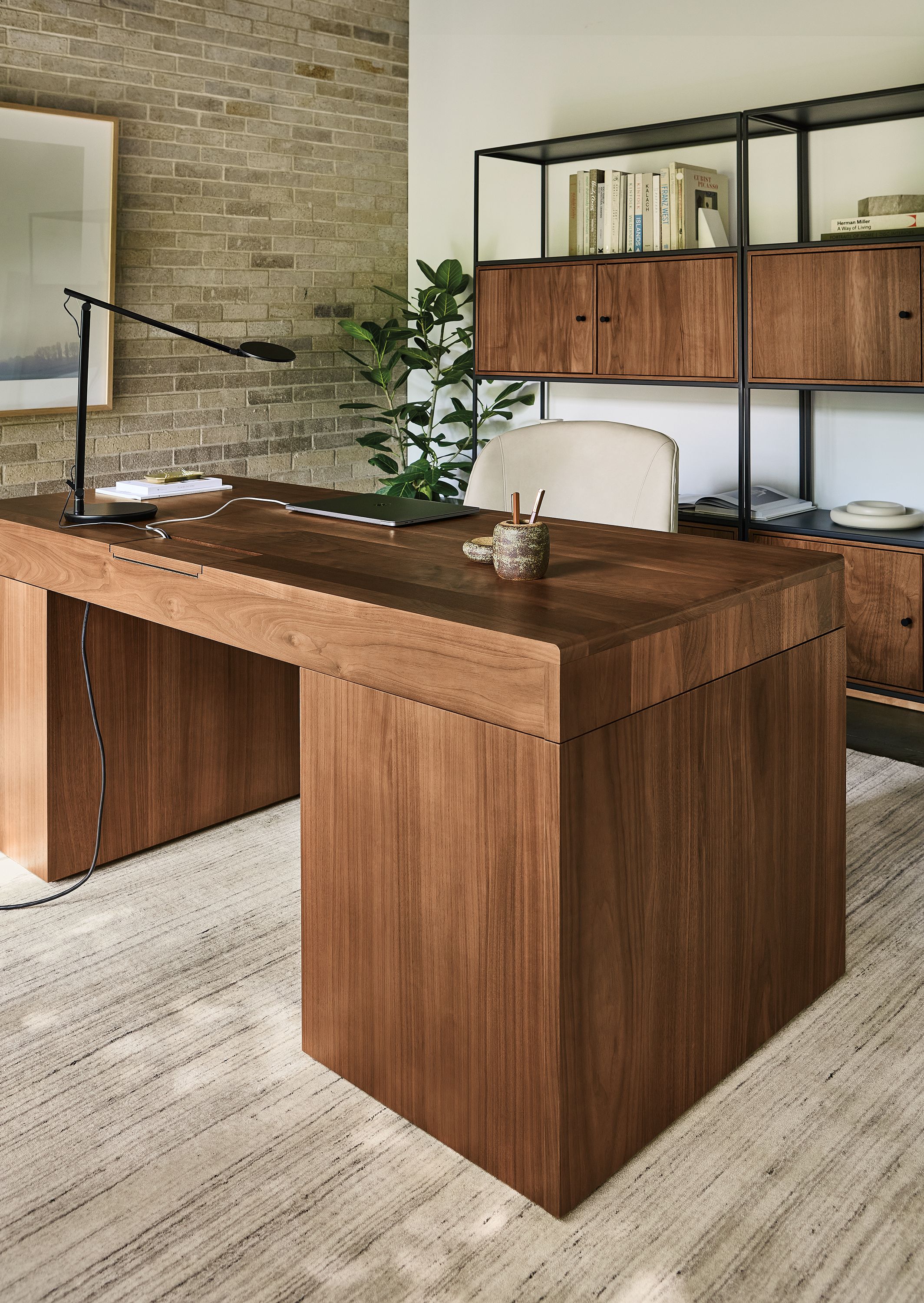 Office with lincoln adjustable standing desk in walnut and slim 4-door insert bookcase in natural steel and walnut.