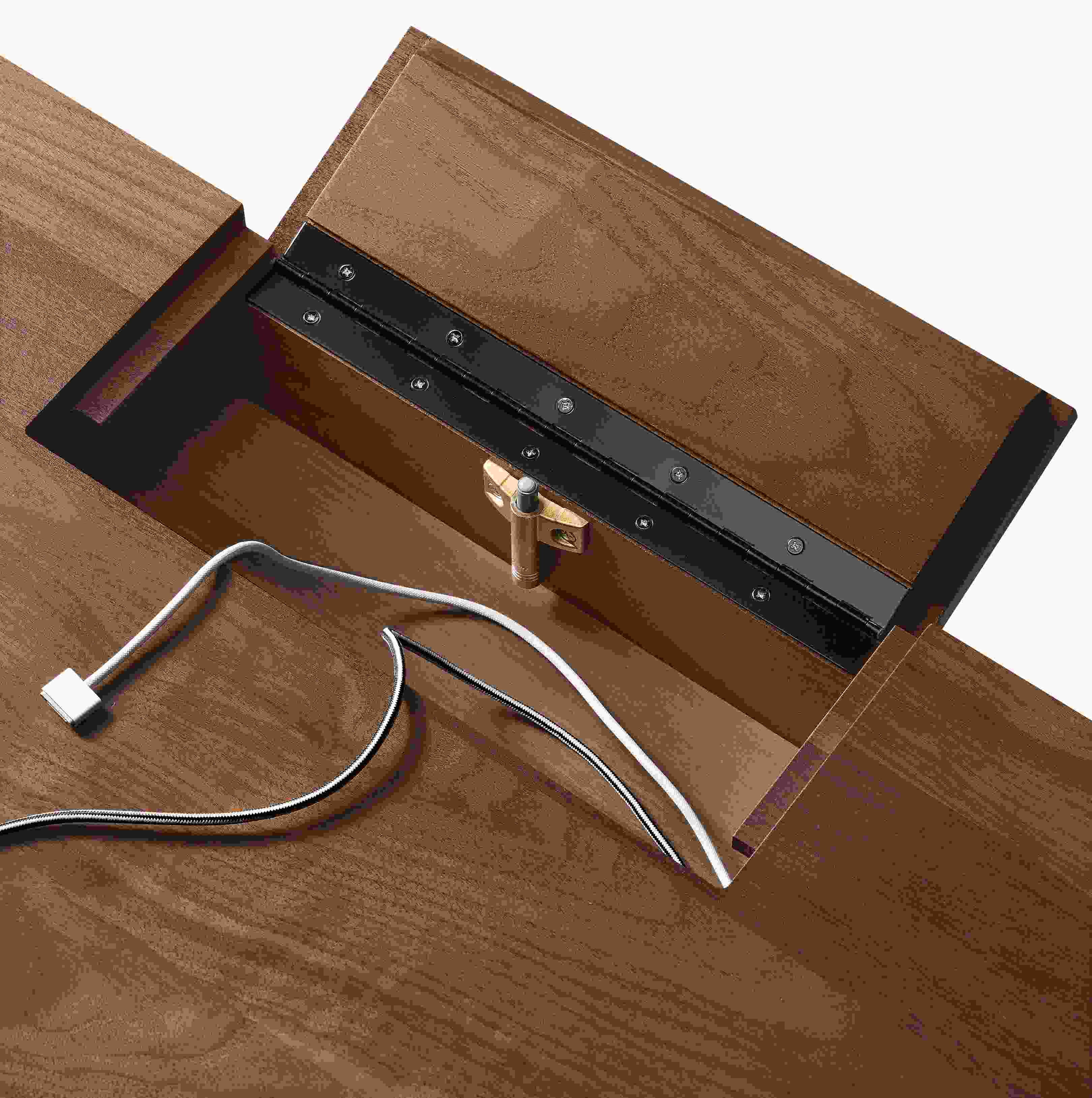 Detail of hinged cord access cover shown open on Lincoln 72-wide adjustable standing desk in walnut.