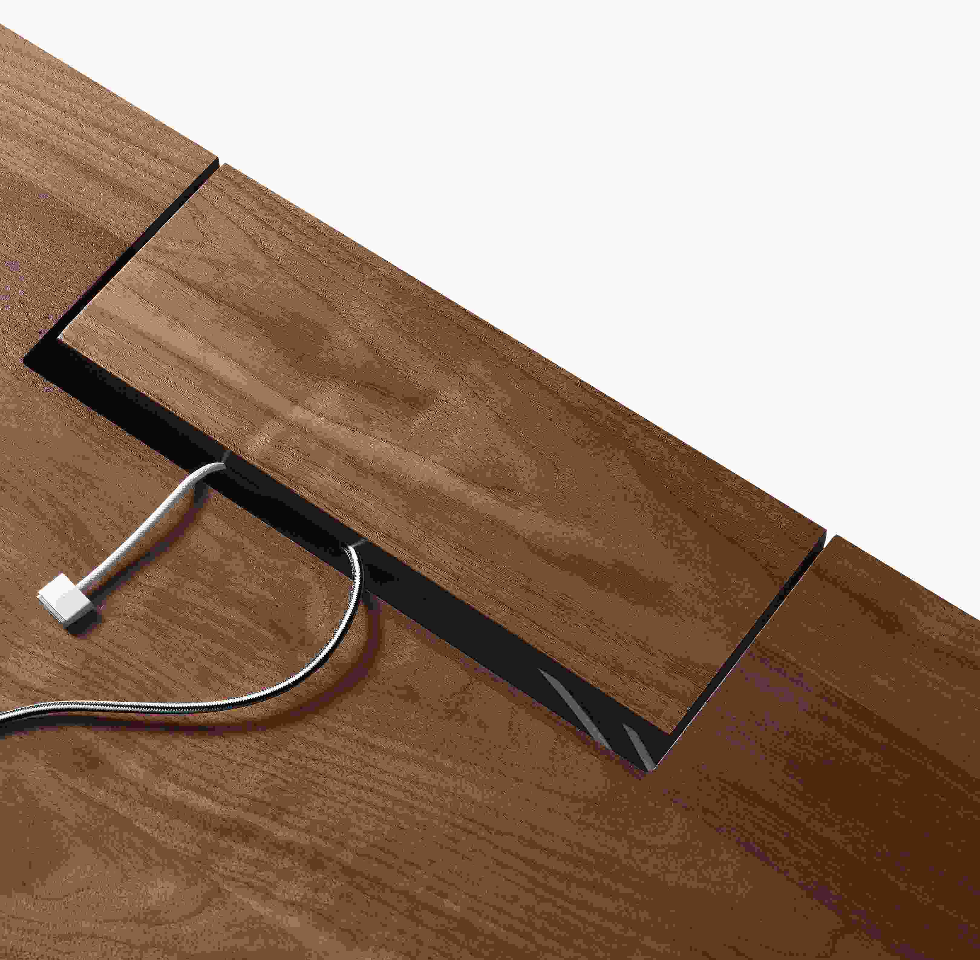 Detail of hinged cord access cover shown closed on Lincoln 72-wide adjustable standing desk in walnut.