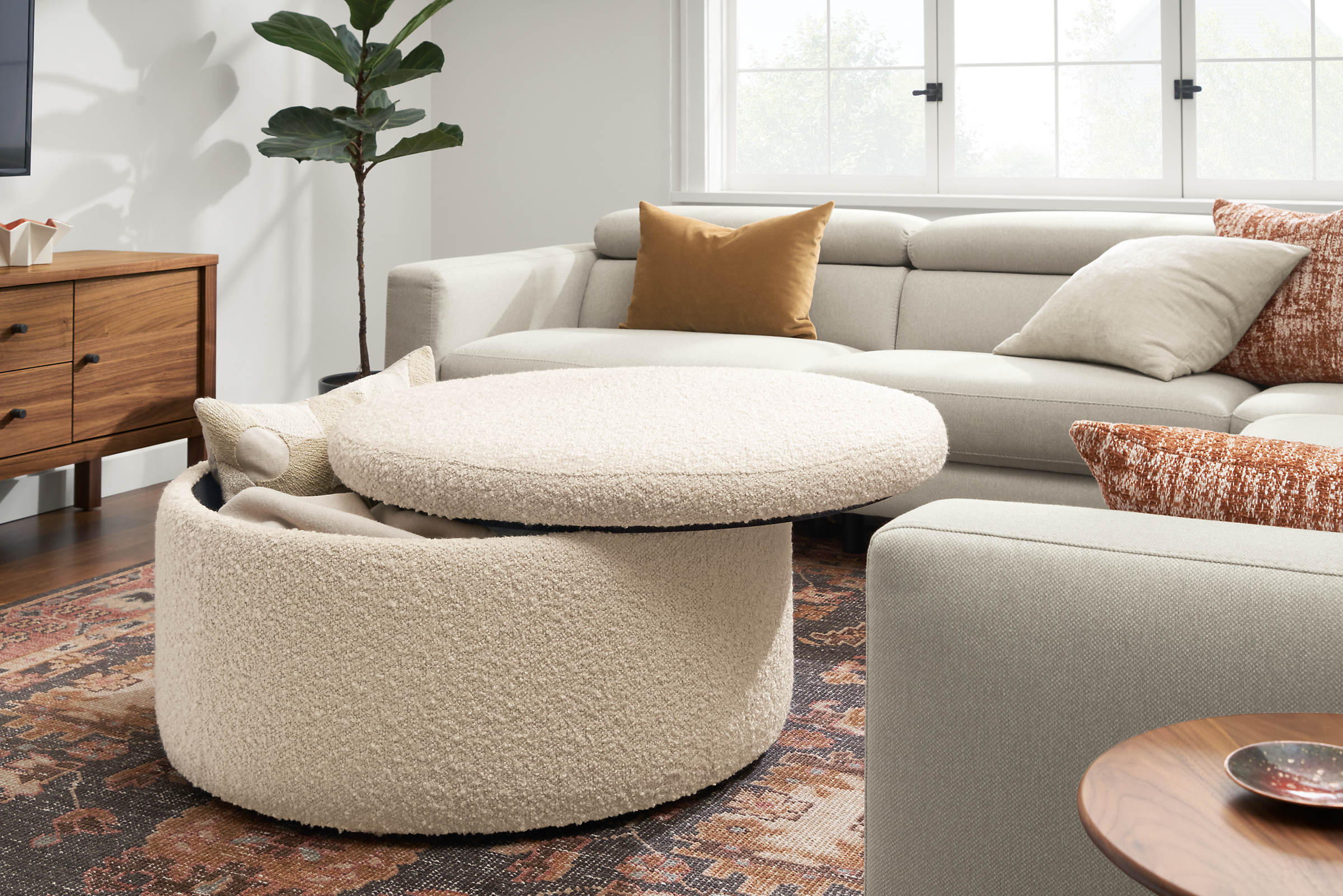 Detail of Lind 36-round storage ottoman in Dornick ivory fabric with top open.