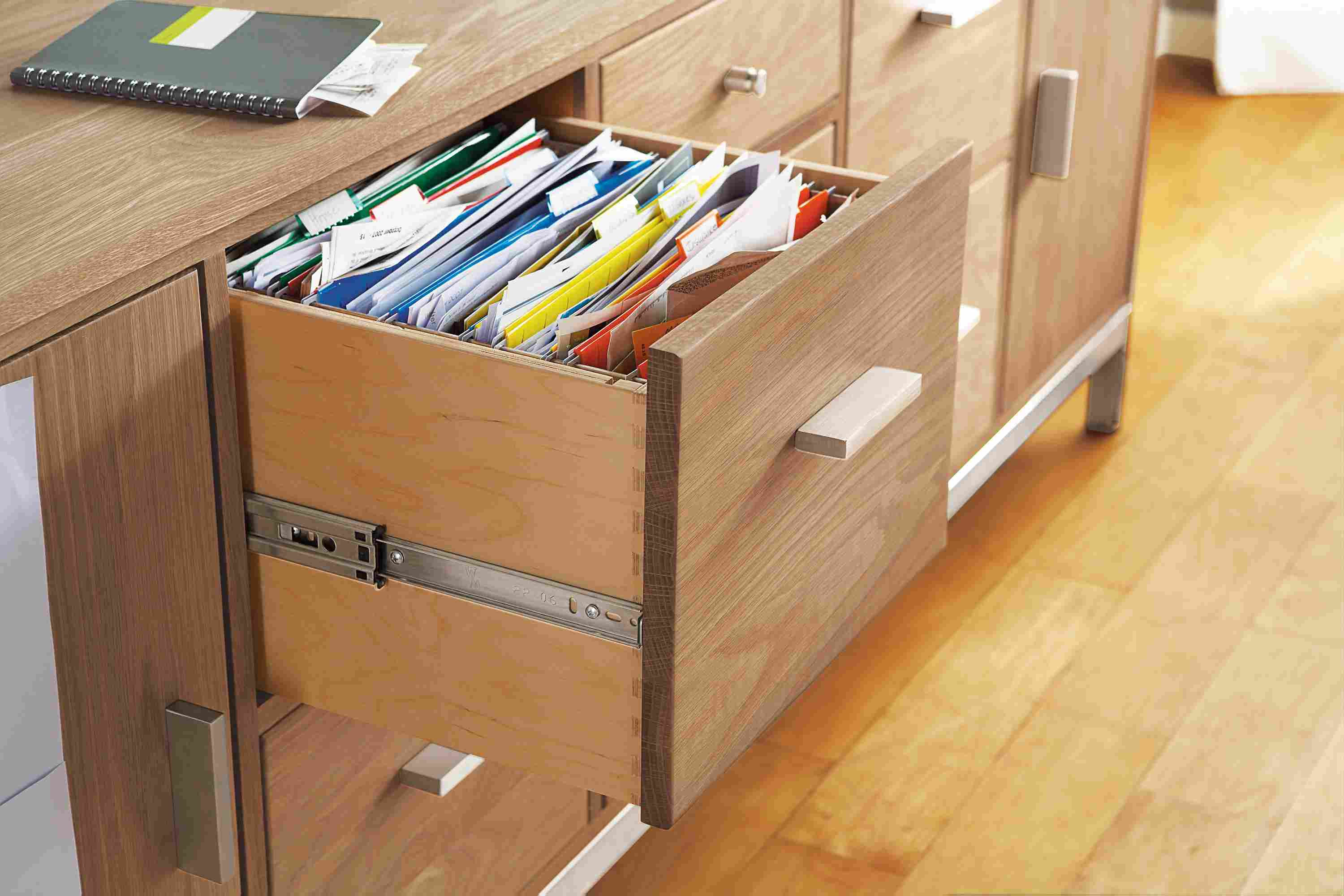 Detail of file drawer on Linear 83-wide office storage cabinet in rye on red oak and stainless steel.