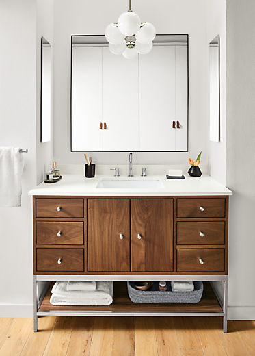 Detail of Linear bathroom vanity in walnut and stainless steel in bathroom.