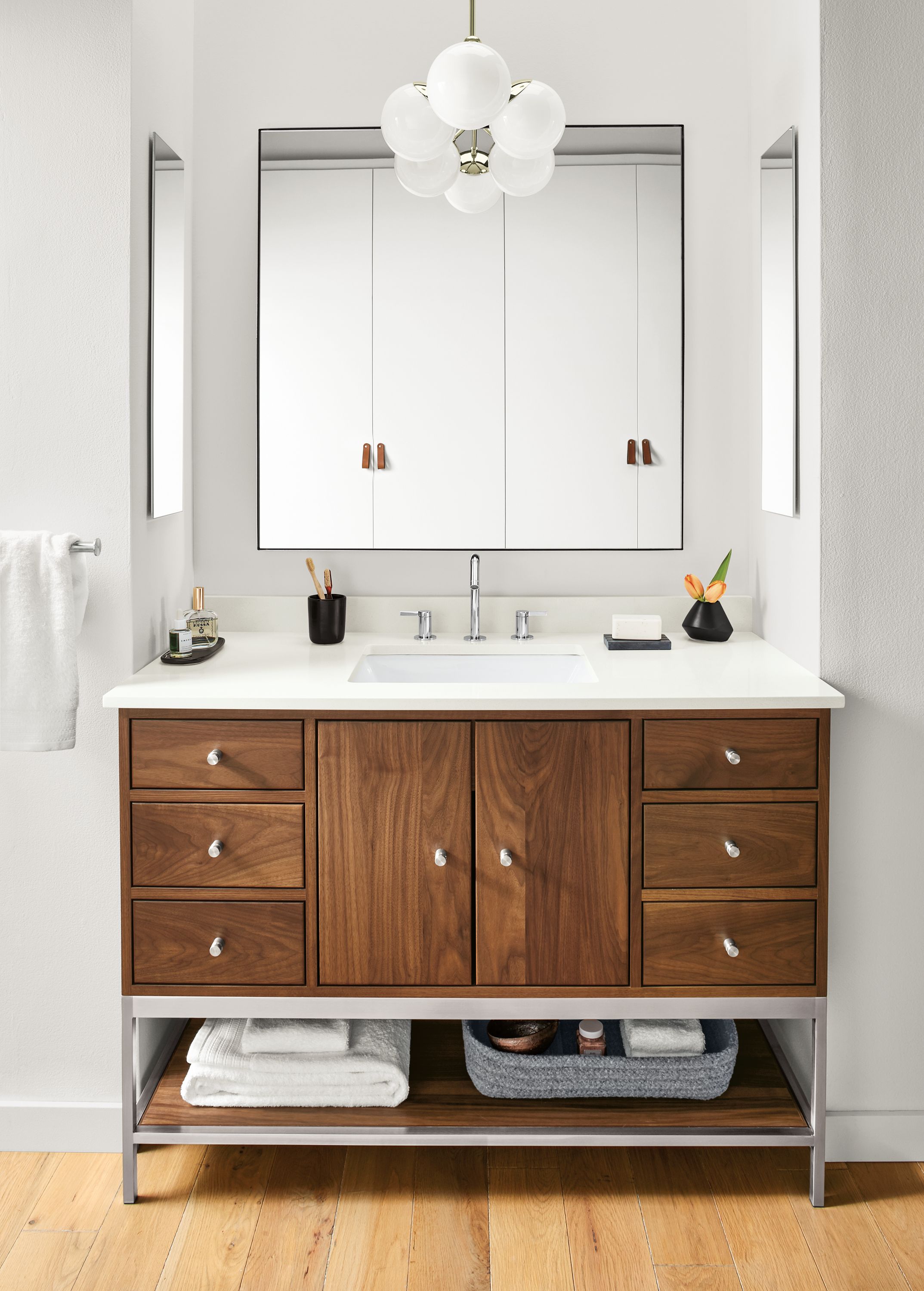 Detail of Linear bathroom vanity in walnut and stainless steel in bathroom.