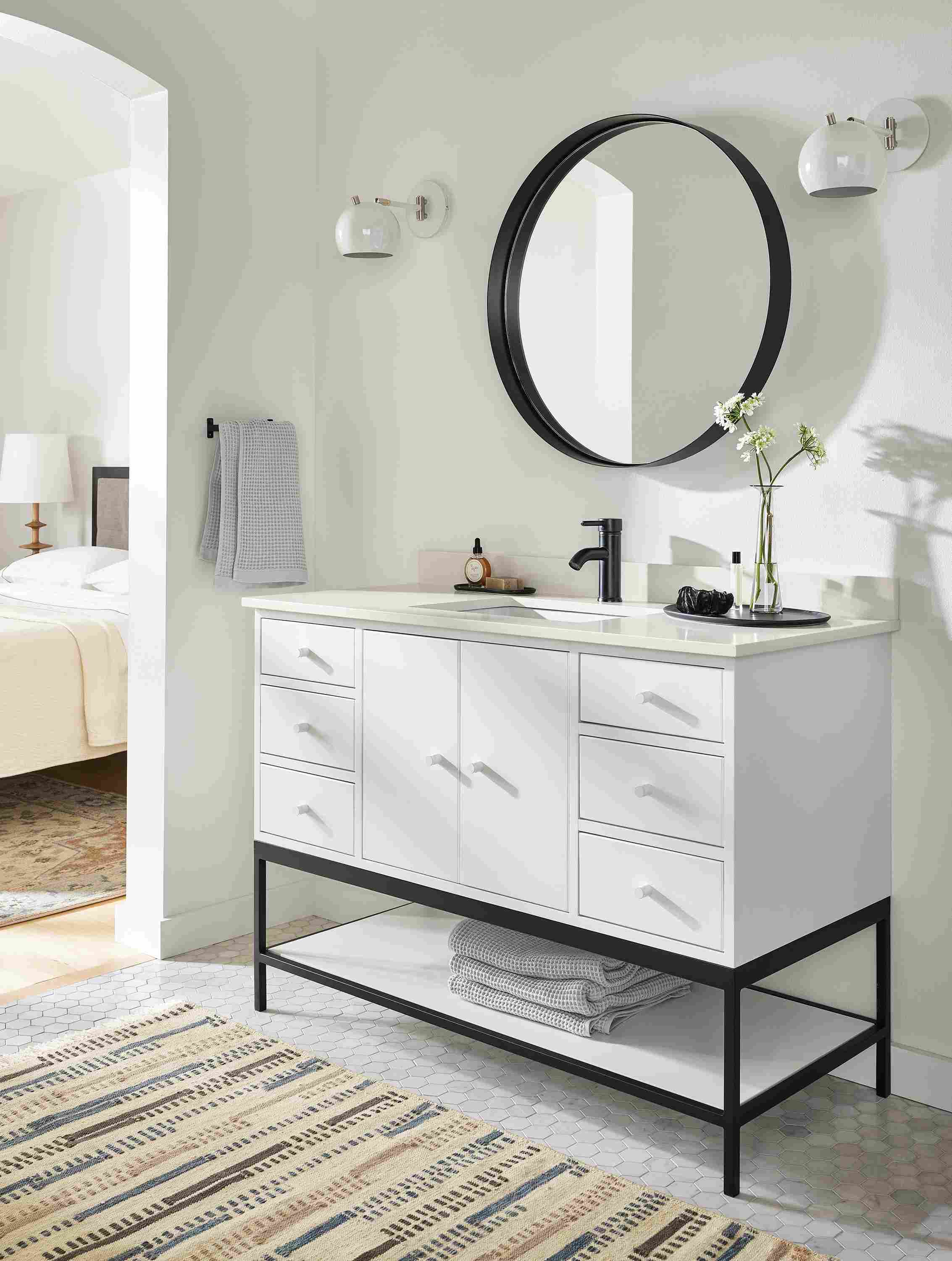 bathroom with 48-wide linear vanity in white, reeves mirror, camber sconces, morse rug.