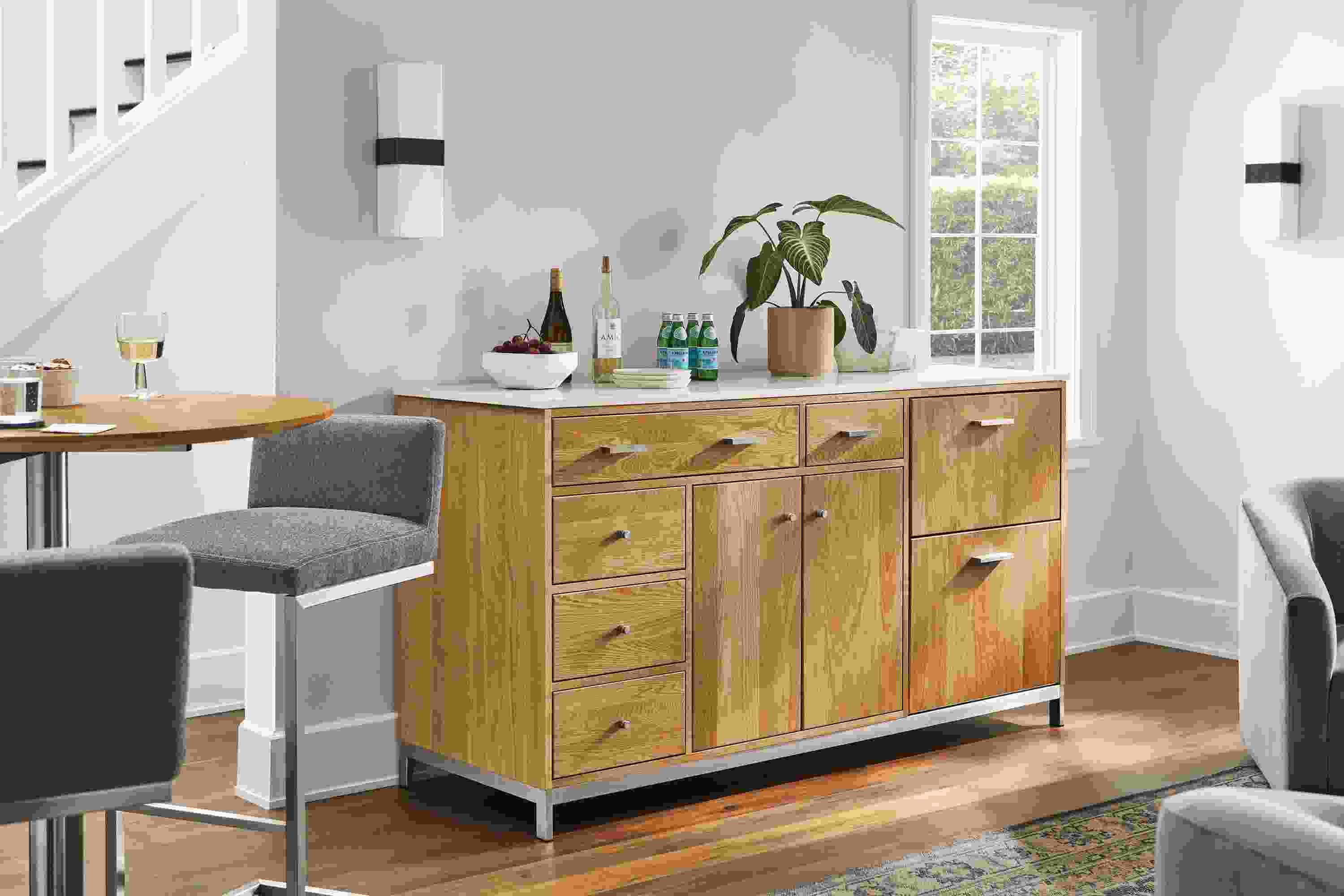 Living room with Linear 72-wide storage cabinet in white oak with refrigeration, Lira stools, Iris scones.