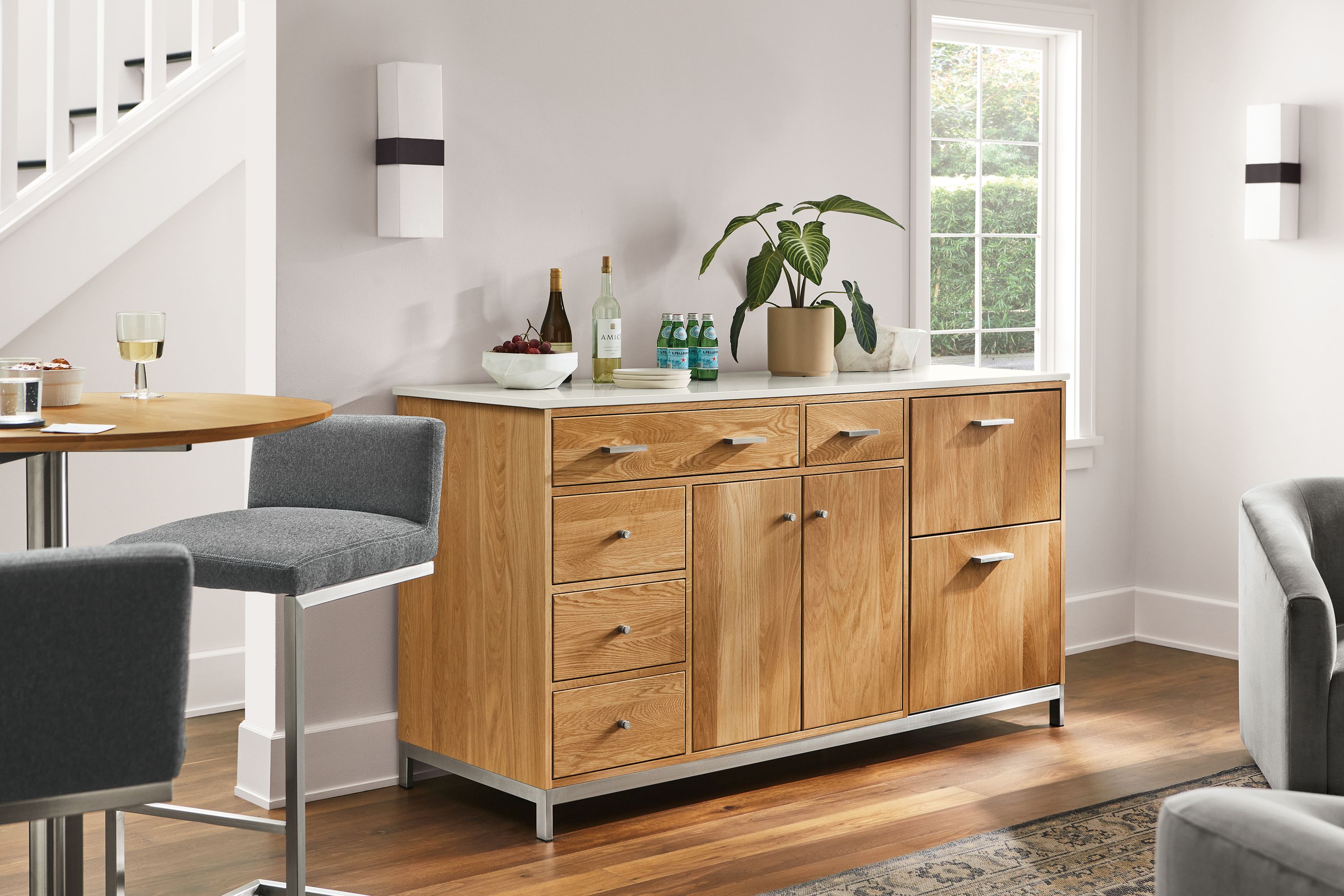 Living room with Linear 72-wide storage cabinet in white oak with refrigeration, Lira stools, Iris scones.