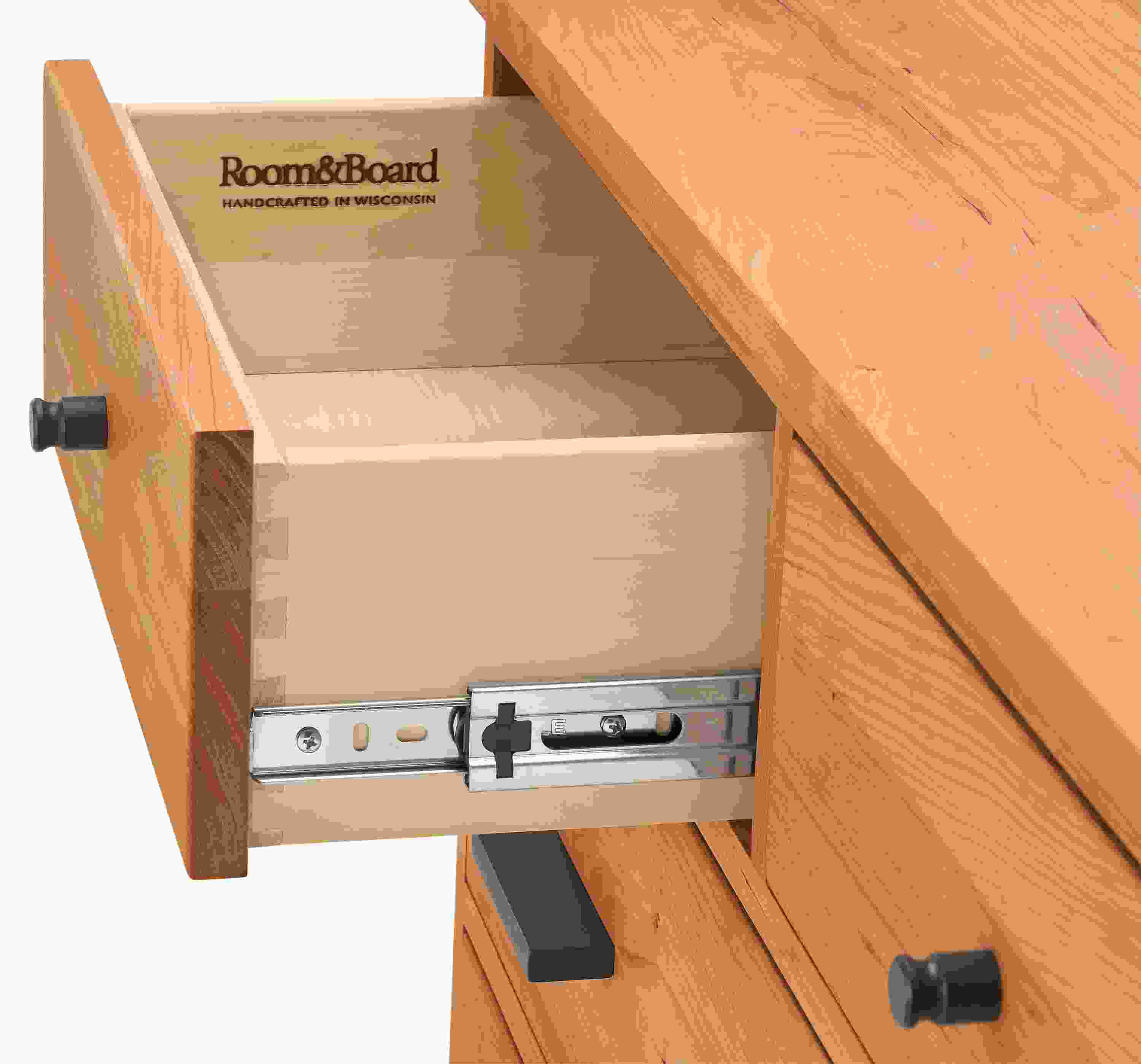 Detail of open drawer and slide mechanism on Linear 10-drawer dresser in cherry finish.