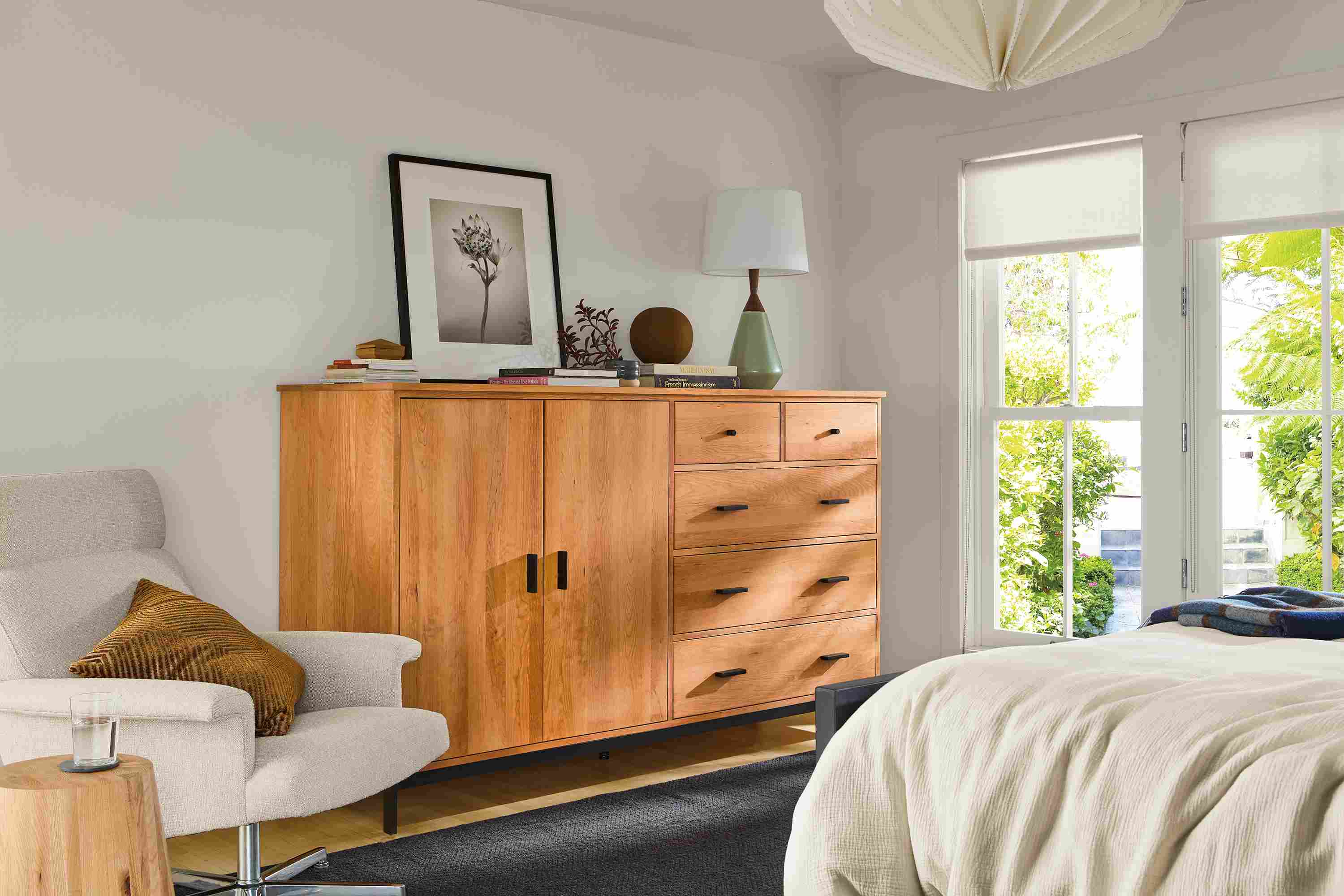 Bedroom with Linear 78-wide armoire in cherry, Daniels swivel chair in Conley natural and Avilia 8 by 10 rug in charcoal.
