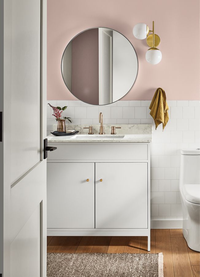 bathroom with linear bathroom vanity in white, infinity round wall mirror, pearl sconce.