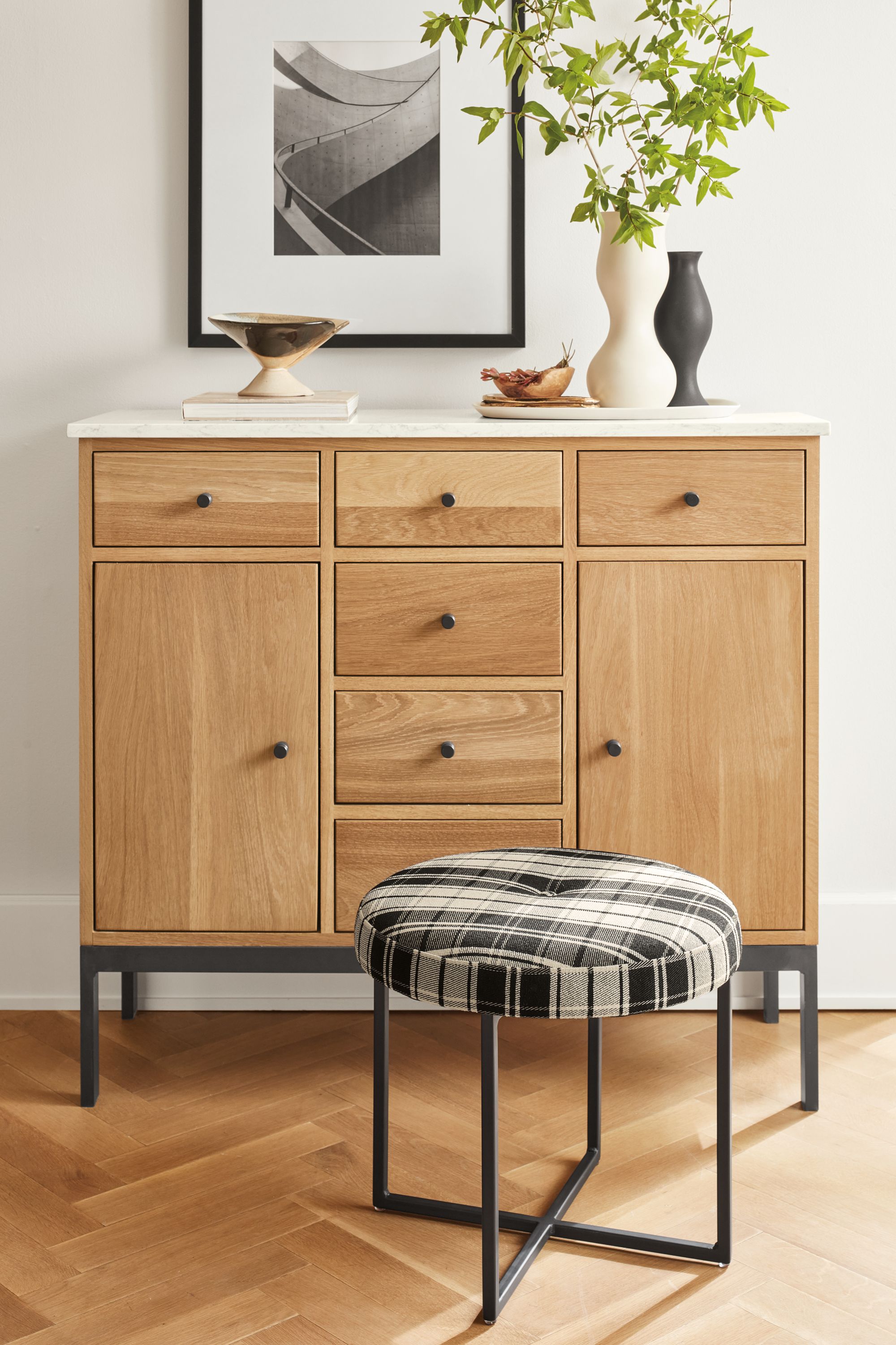 Living area with Linear 42-wide storage cabinet in white oak and natural steel with Marbled white quartz top and Sidney ottoman.