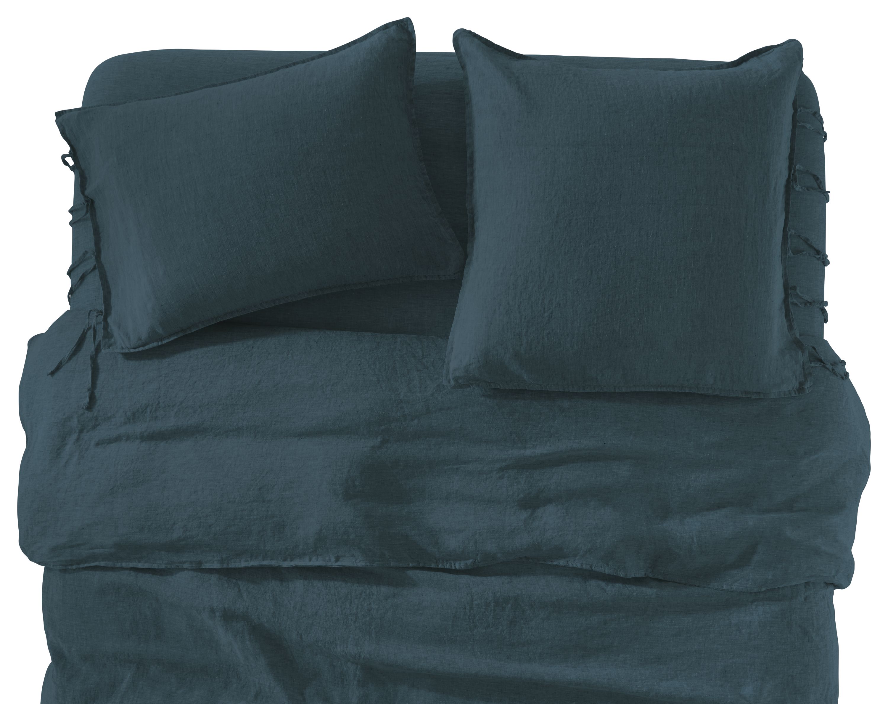 detail of relaxed linen sheet set, shams, duvet cover in dark slate on bed.
