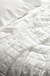 Close-up of relaxed linen full/queen quilted coverlet and relaxed linen queen sheet set in white.