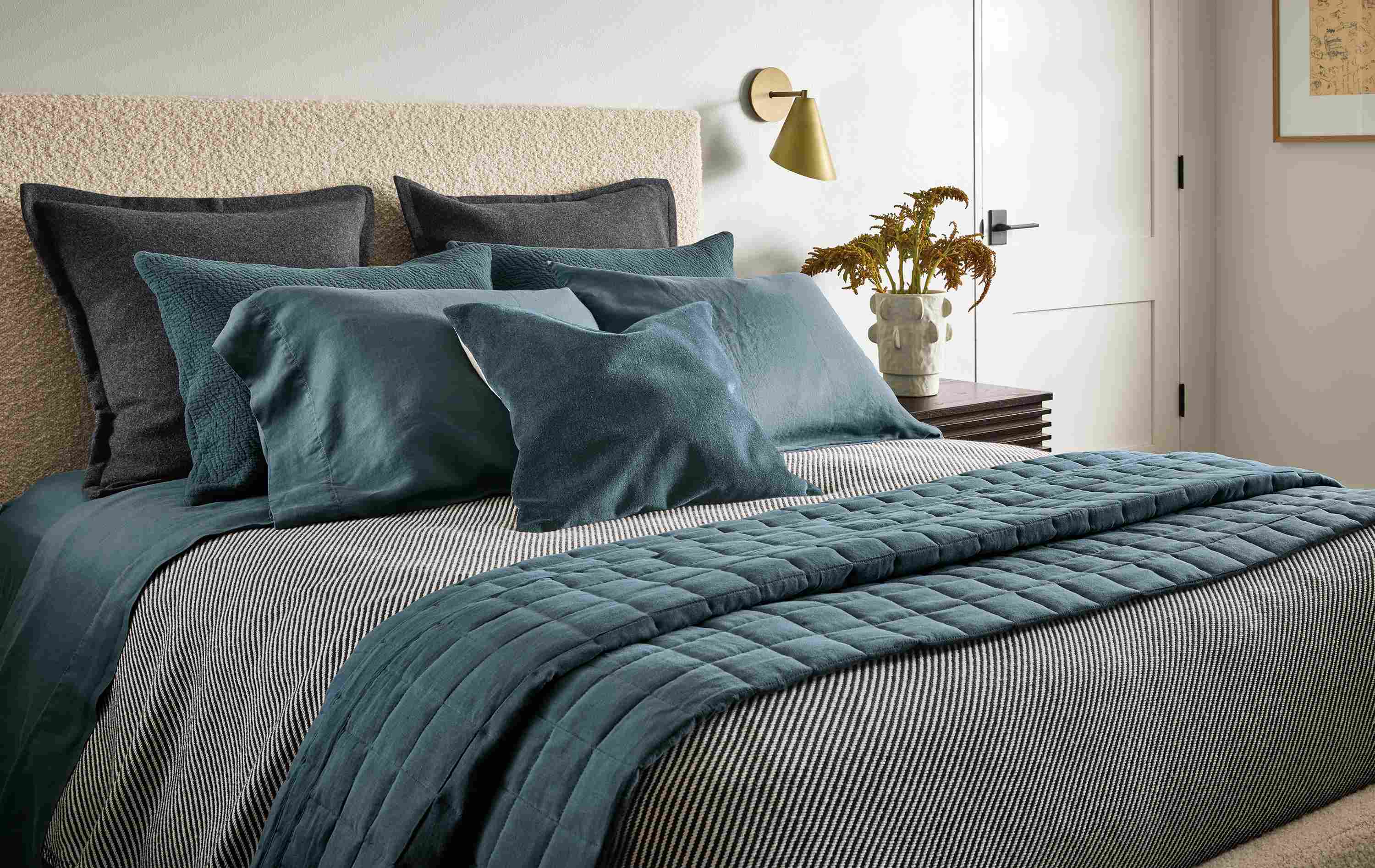 Bedroom with relaxed linen quilted coverlet in dark slate, finchley blanket in black/ivory and washable wool sham in charcoal.