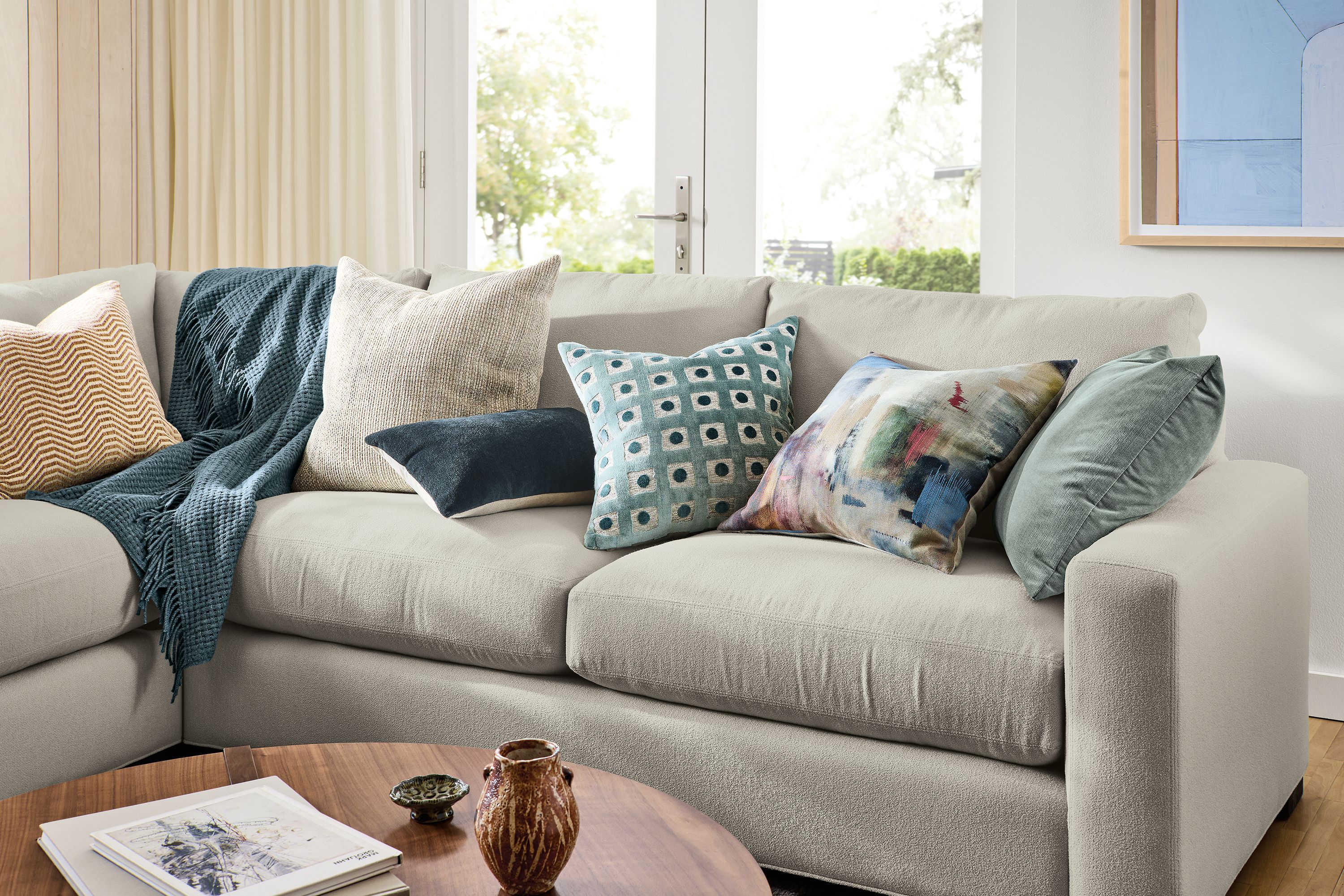 Living room with detail of Metro 3-piece sofa with various pillows including Lines, Arcade, Wool Velvet and Tilden.