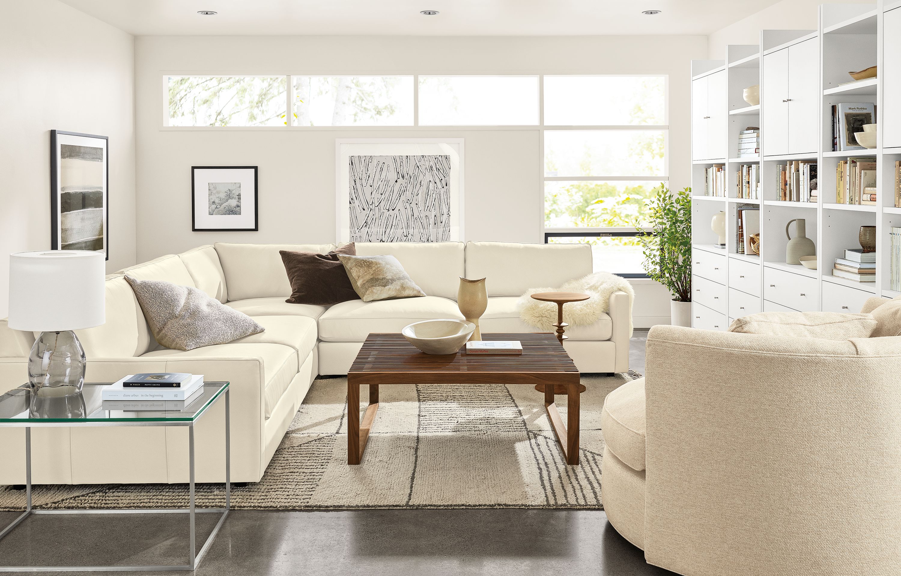 Living area with Linger Deep 119-inch three-piece sectional in Pesaro Ivory and Eos Chair.