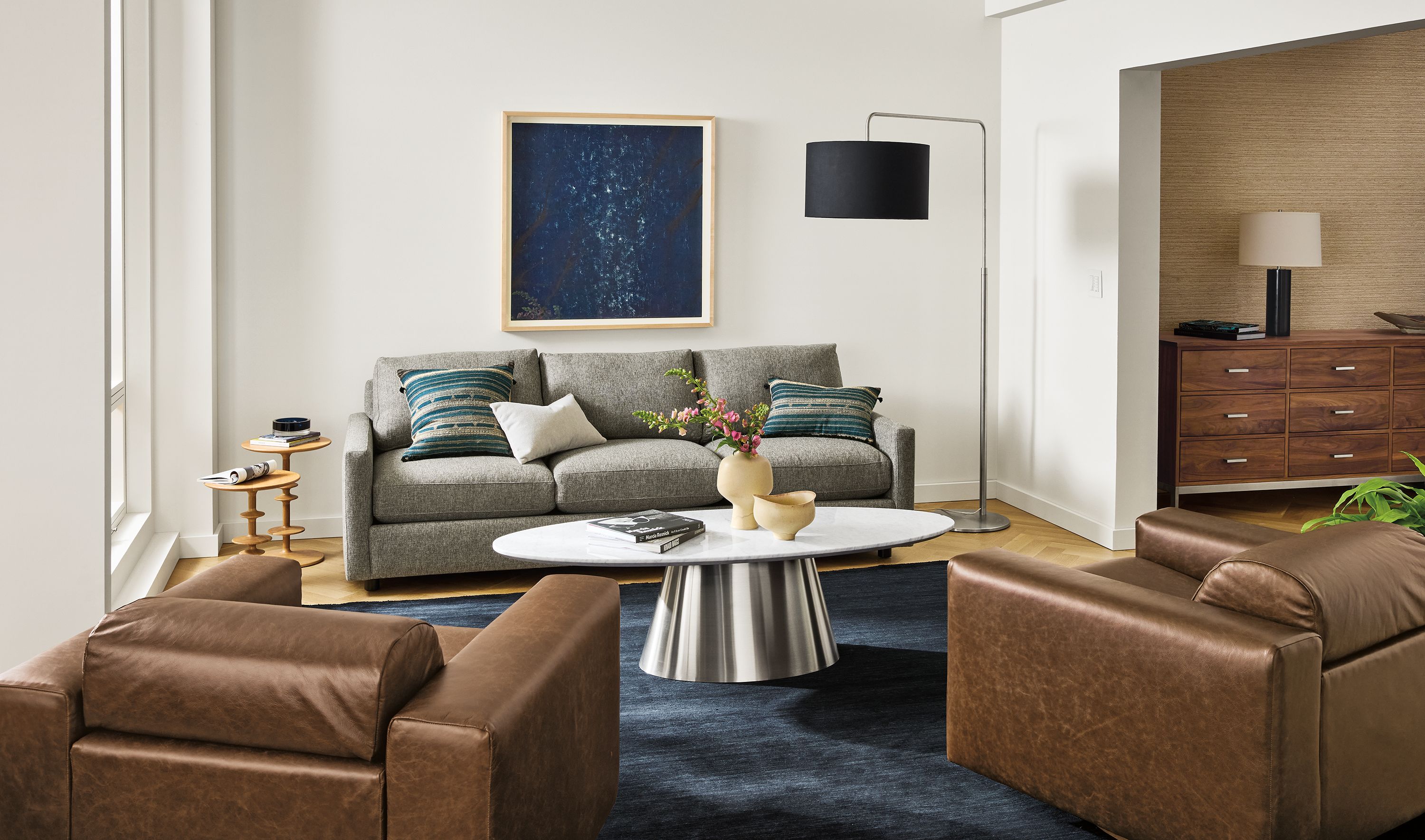 Living room with Linger sofa in Tepic Grey, 2 Harmon swivel chair in Palermo Bourbon leather and 2 Parks end tables.