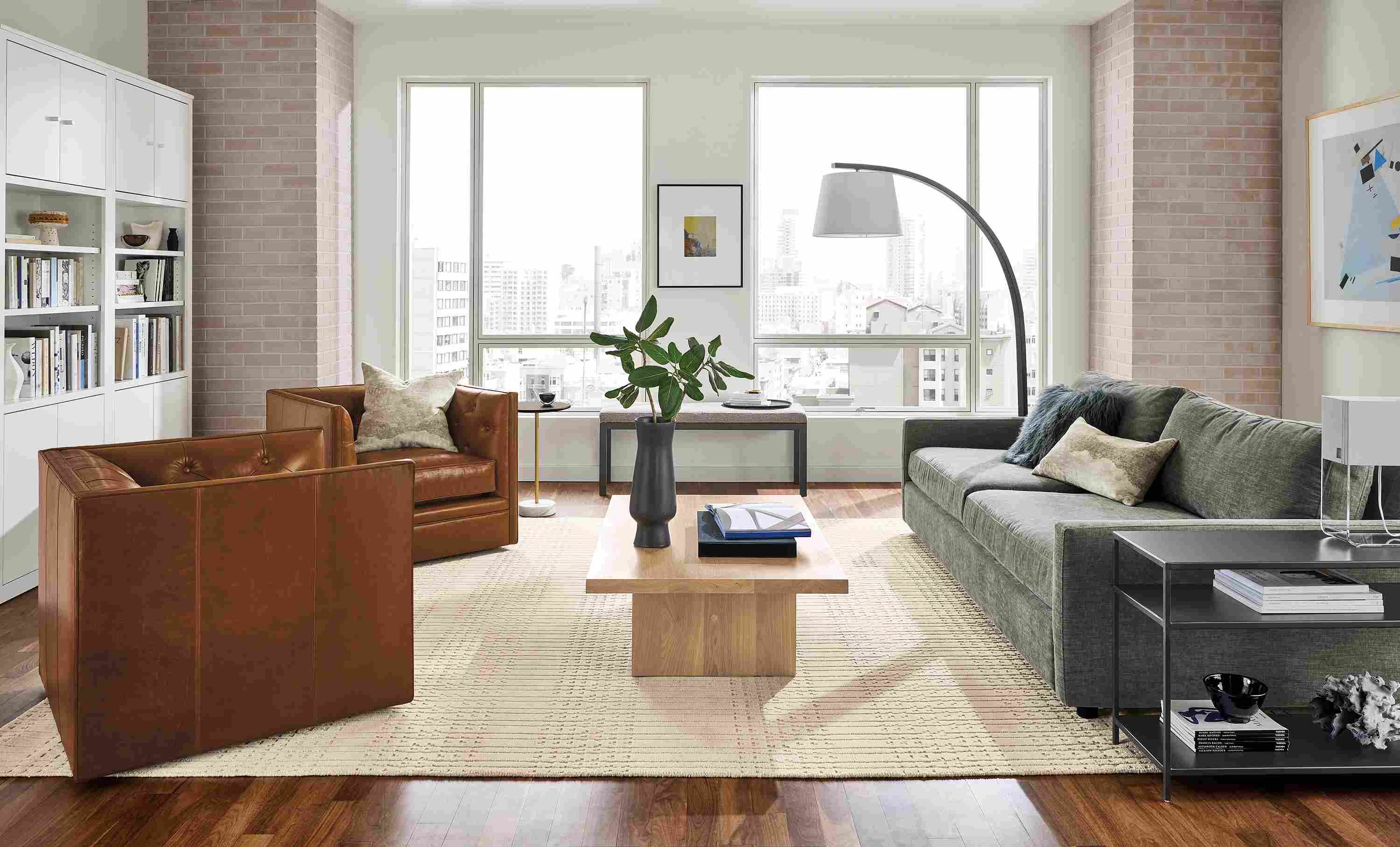 Living room with 91-wide Linger deep sofa in mori graphite, Macalester swivel chairs in vento cognac leather.