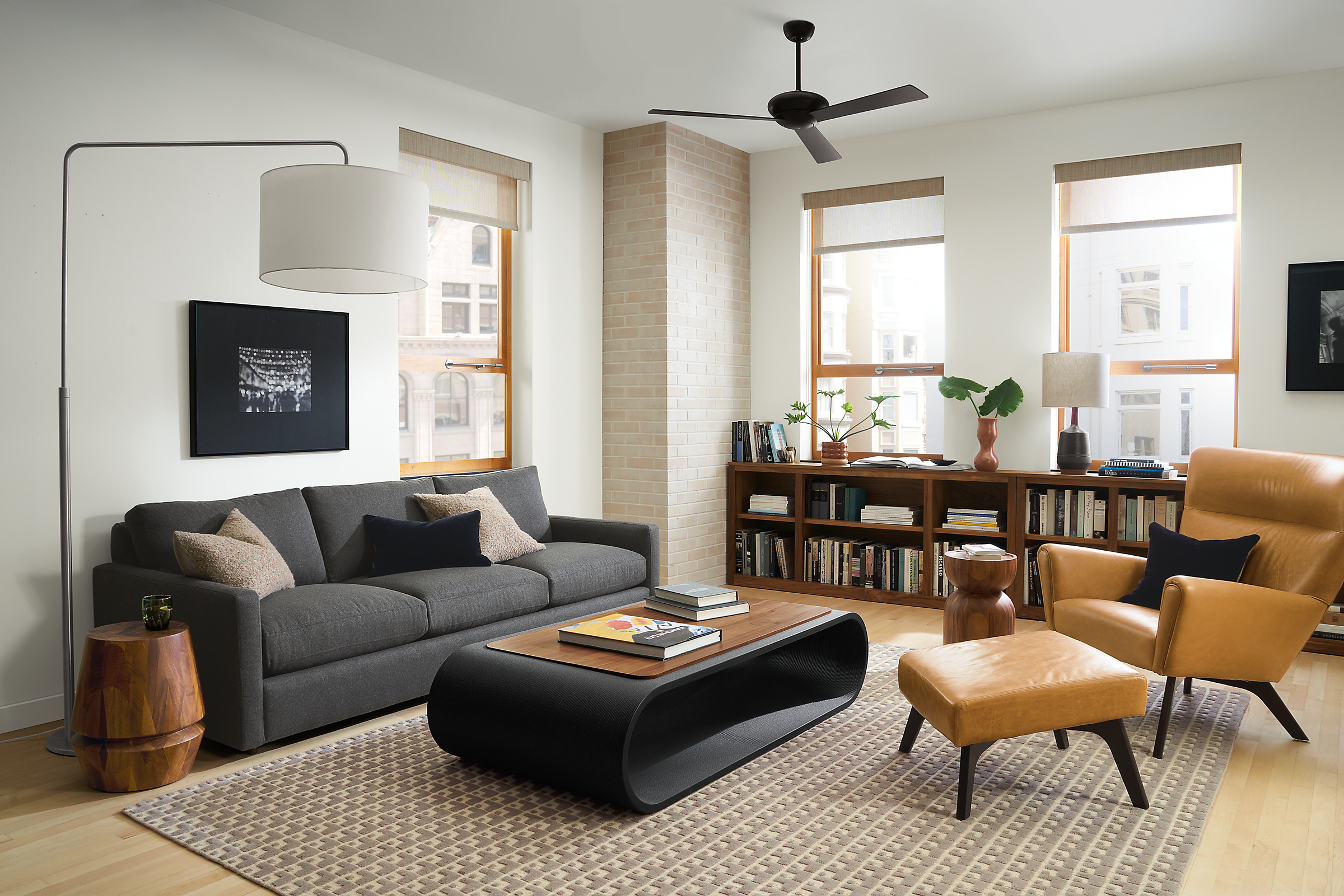 Living room setting with Linger 91-inch Sofa in Flint Charcoal fabric, Boden Chair and Ottoman in Vento Camel leather and Tangent Coffee Table in Black with Walnut top..