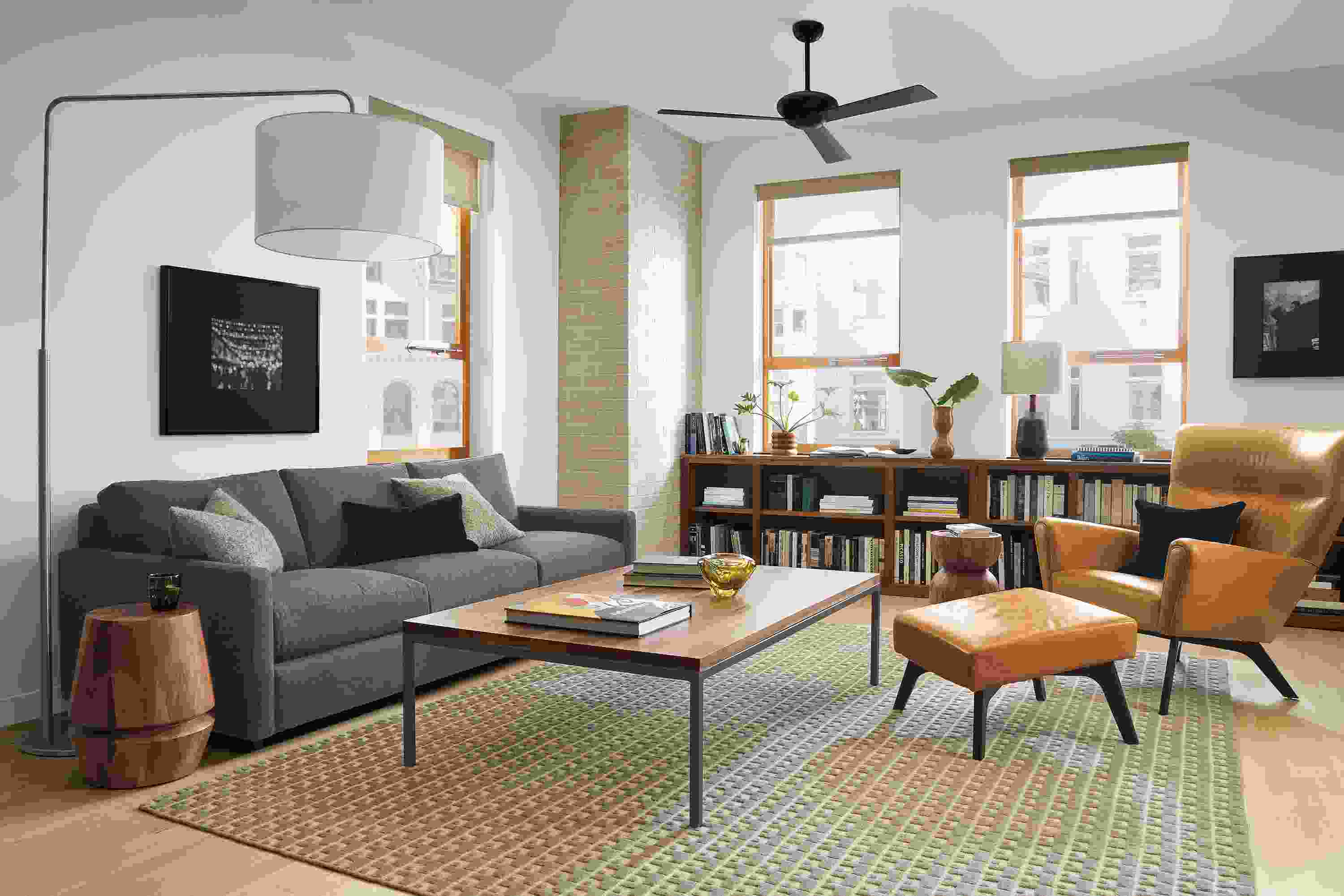 Living room setting with Linger 91-inch Sofa in Flint Charcoal fabric, Boden Chair and Ottoman in Vento Camel leather and Parson Coffee Table in Natural Steel and Walnut.