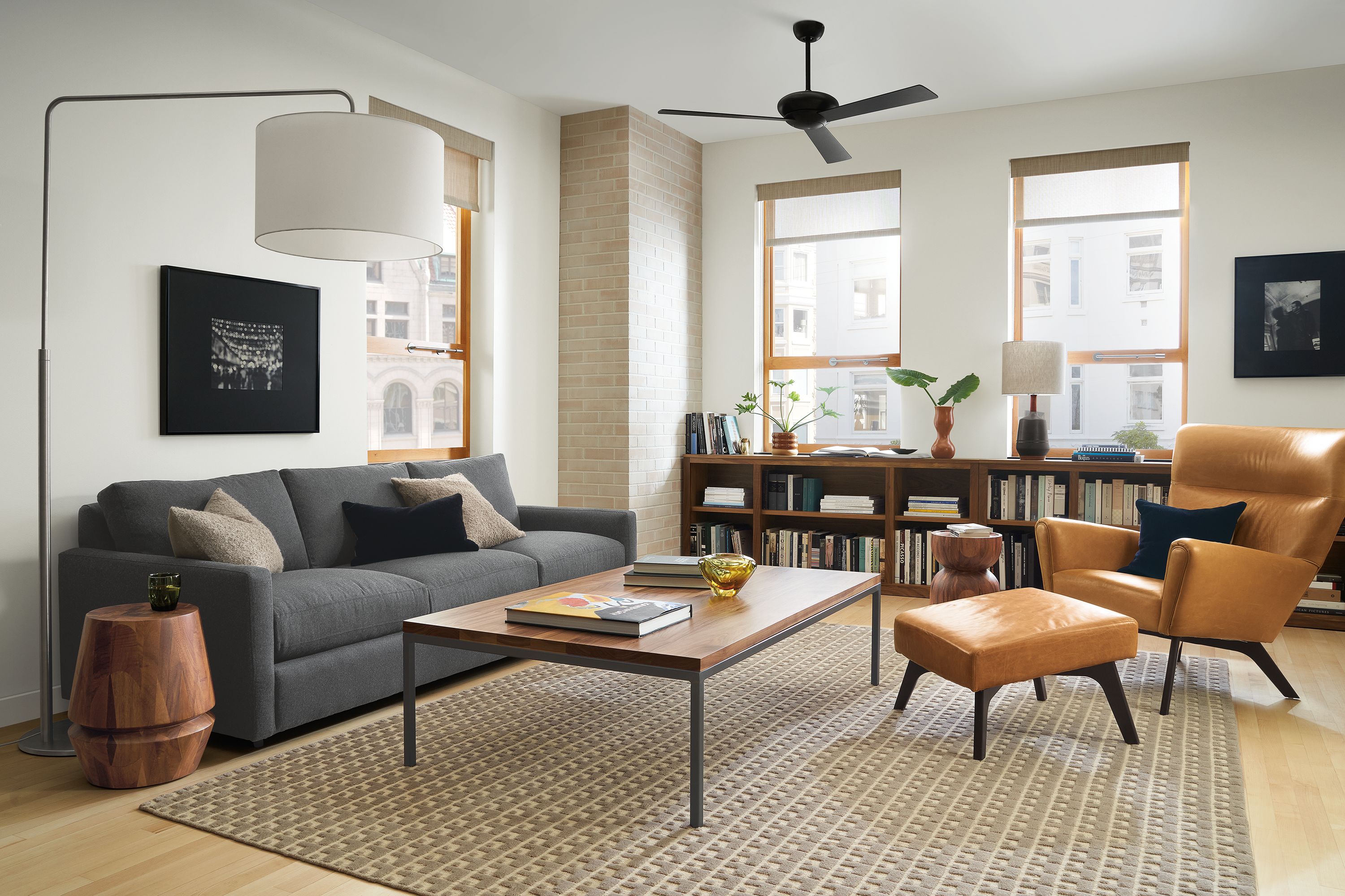 Living room setting with Linger 91-inch Sofa in Flint Charcoal fabric, Boden Chair and Ottoman in Vento Camel leather and Parson Coffee Table in Natural Steel and Walnut.