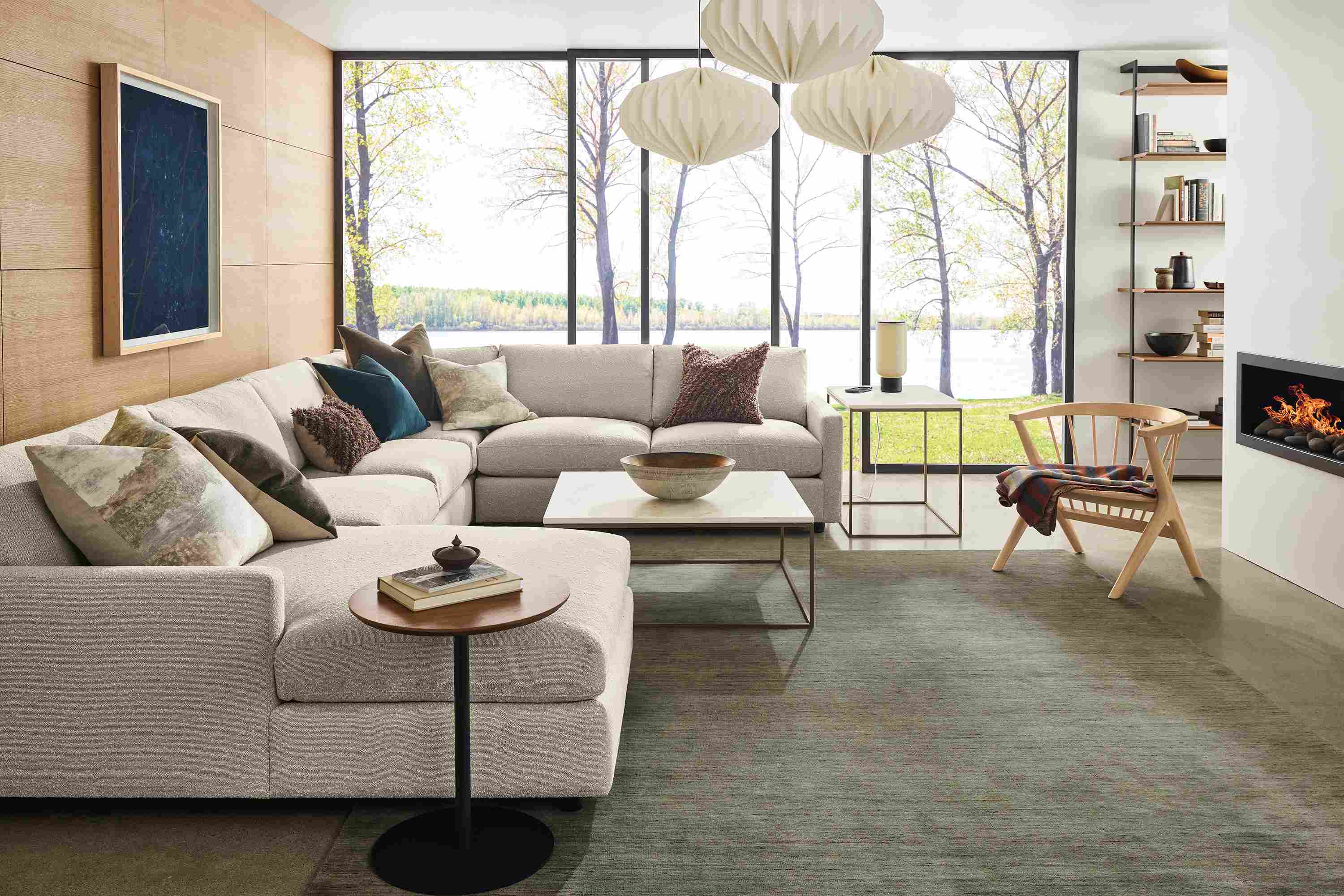 Living room with Linger 4-piece sectional sofa in Declan Natural, Nomad rug in olive and Tyne coffee and end tables.