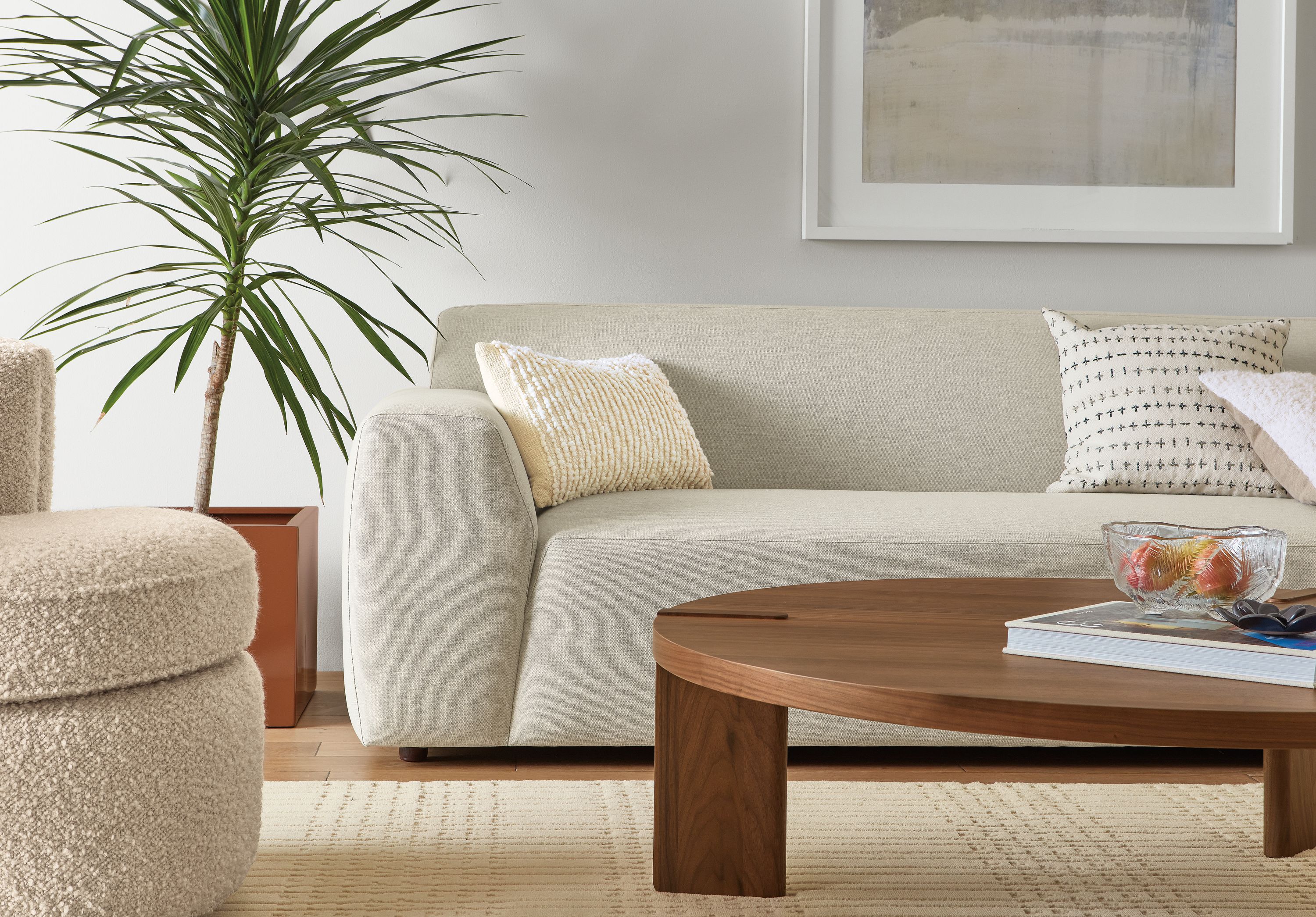 Living room with Linville 118-inch Sofa with Right-Arm Chaise in Yana Natural fabric and Hanover Coffee Table in Walnut.