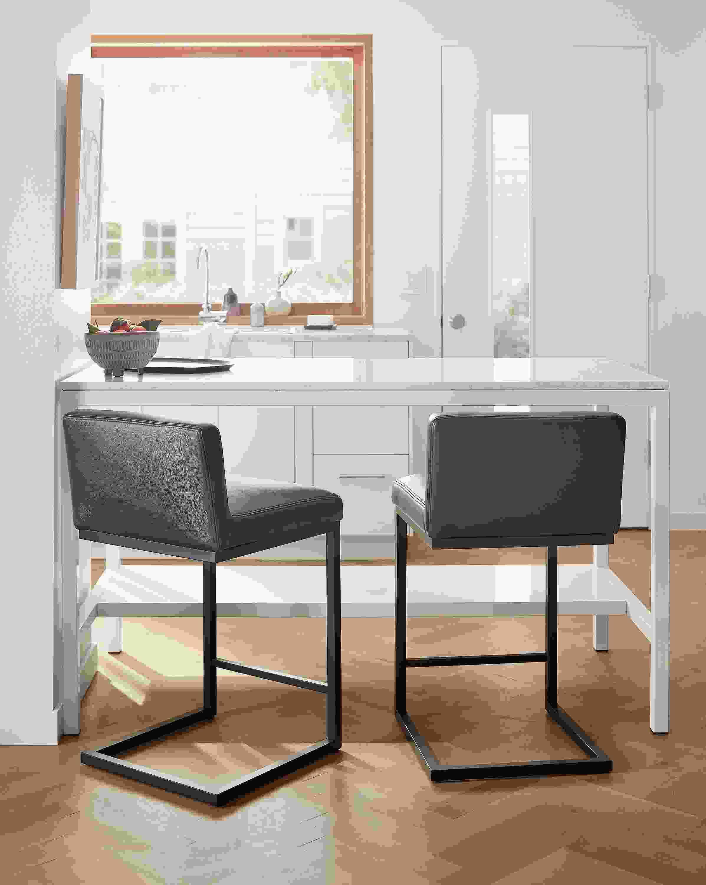 Kitchen counter with 2 lira counter stools in Laino Black leather with graphite and parsons table in white.