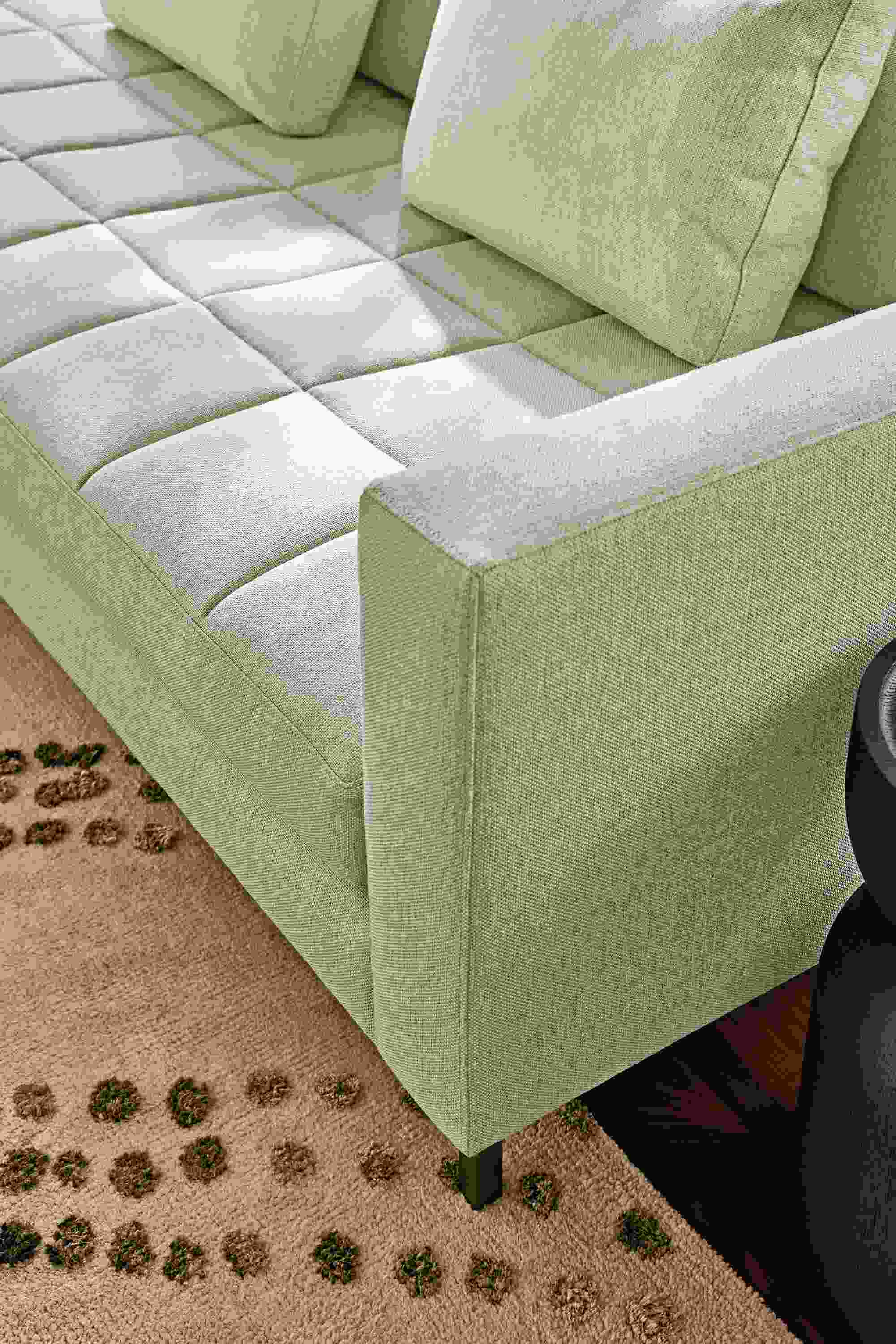 Detail of arm of a Lloyd sectional sofa in Sumner Linen and Sitara rug in Pewter.