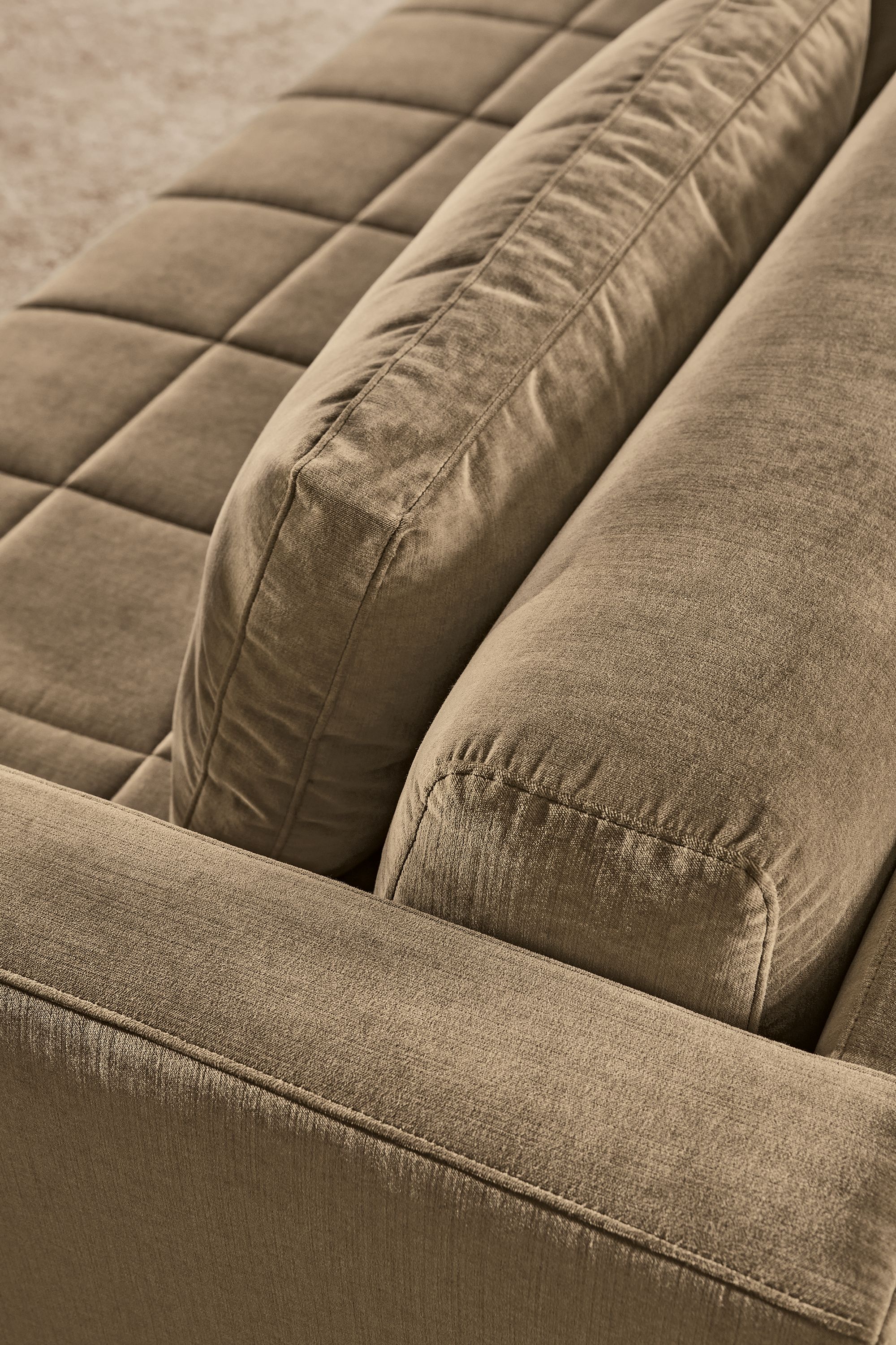High-angle detail of cushions on a Lloyd 92-wide bench cushion sofa in Windsor Otter and Kalindi 8 by 10 rug in flax.
