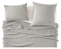 detail of loren coverlet and shams in grey on bed.