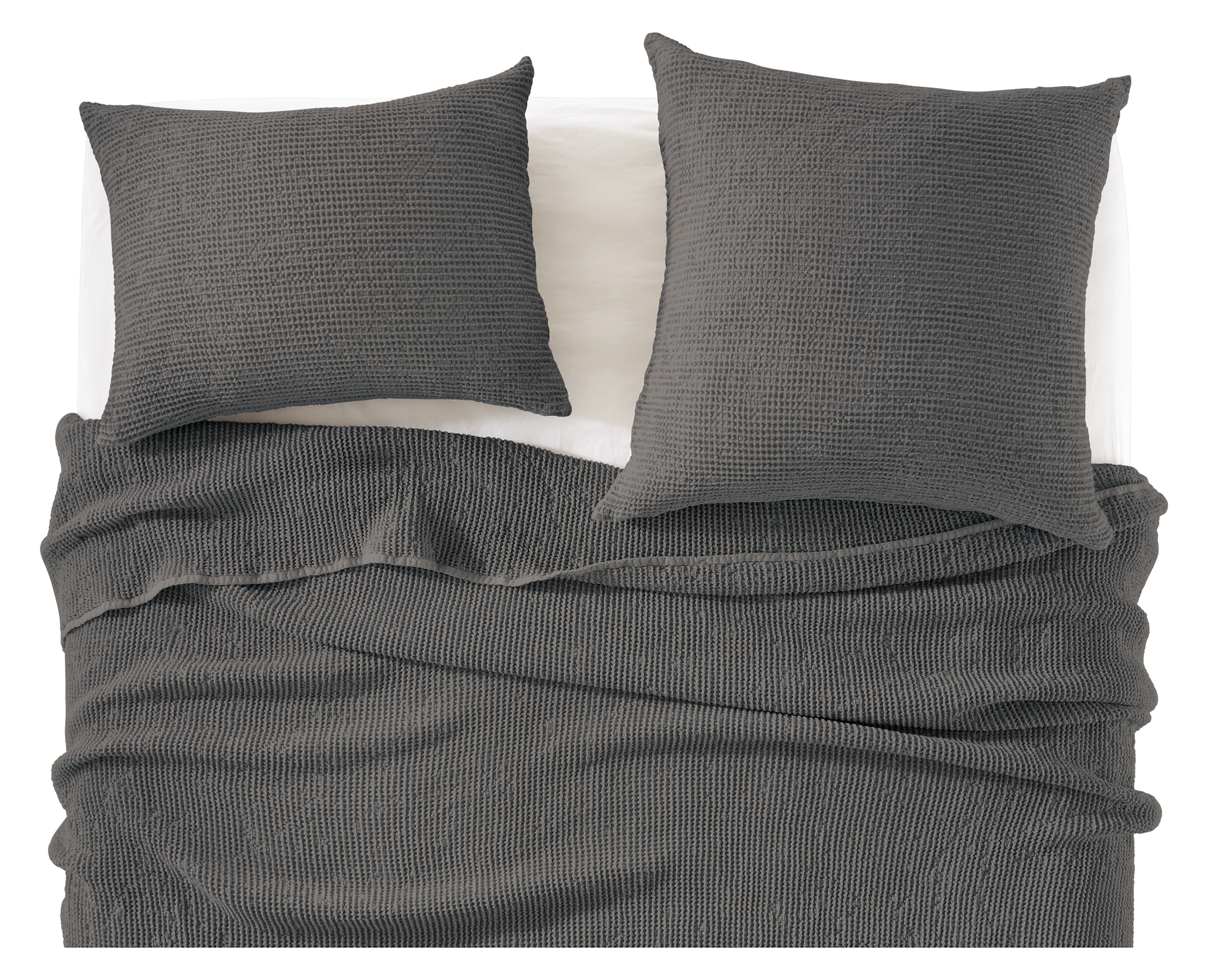 detail of loren coverlet and shams in charcoal on bed.