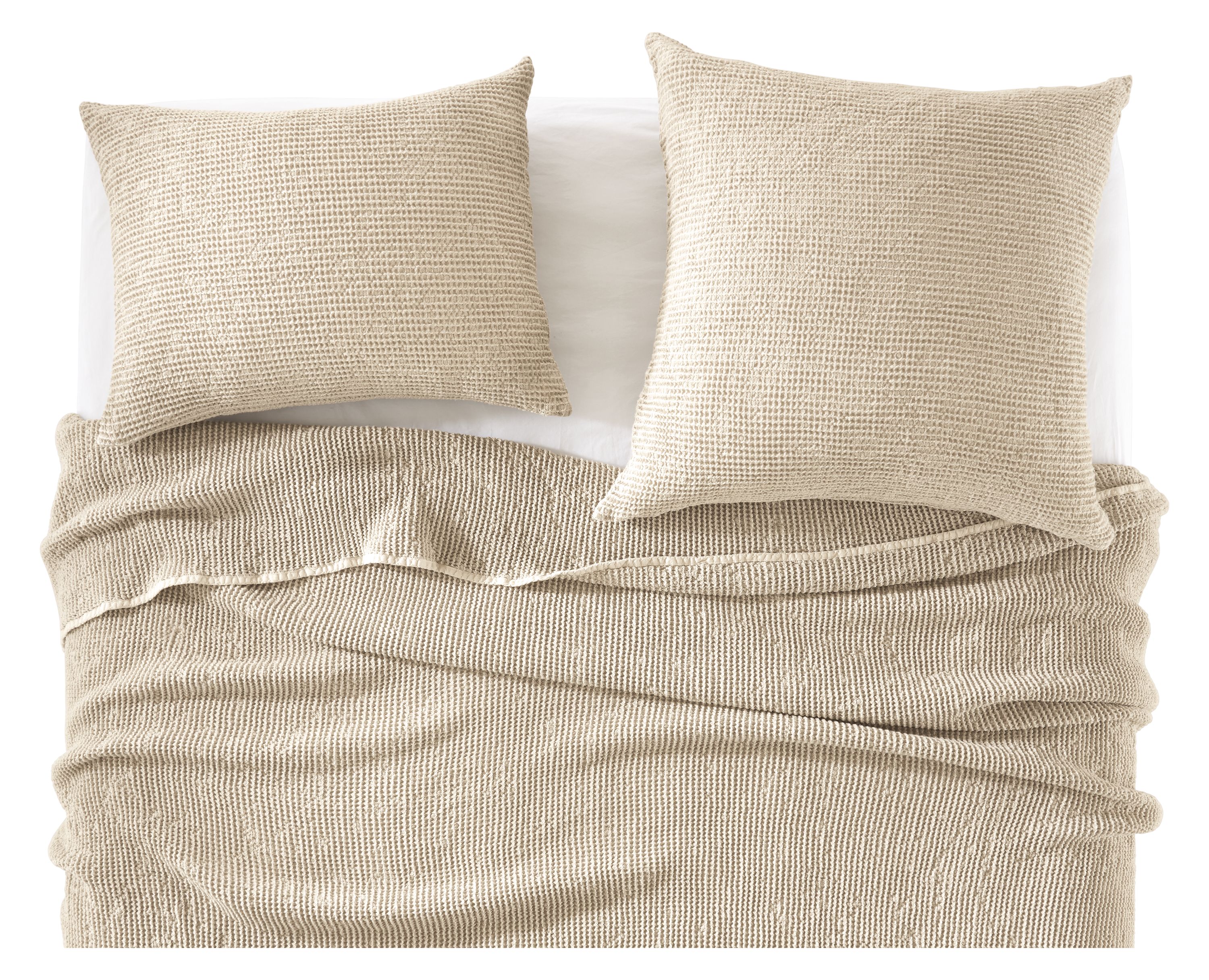 detail of loren coverlet and shams in natural on bed.