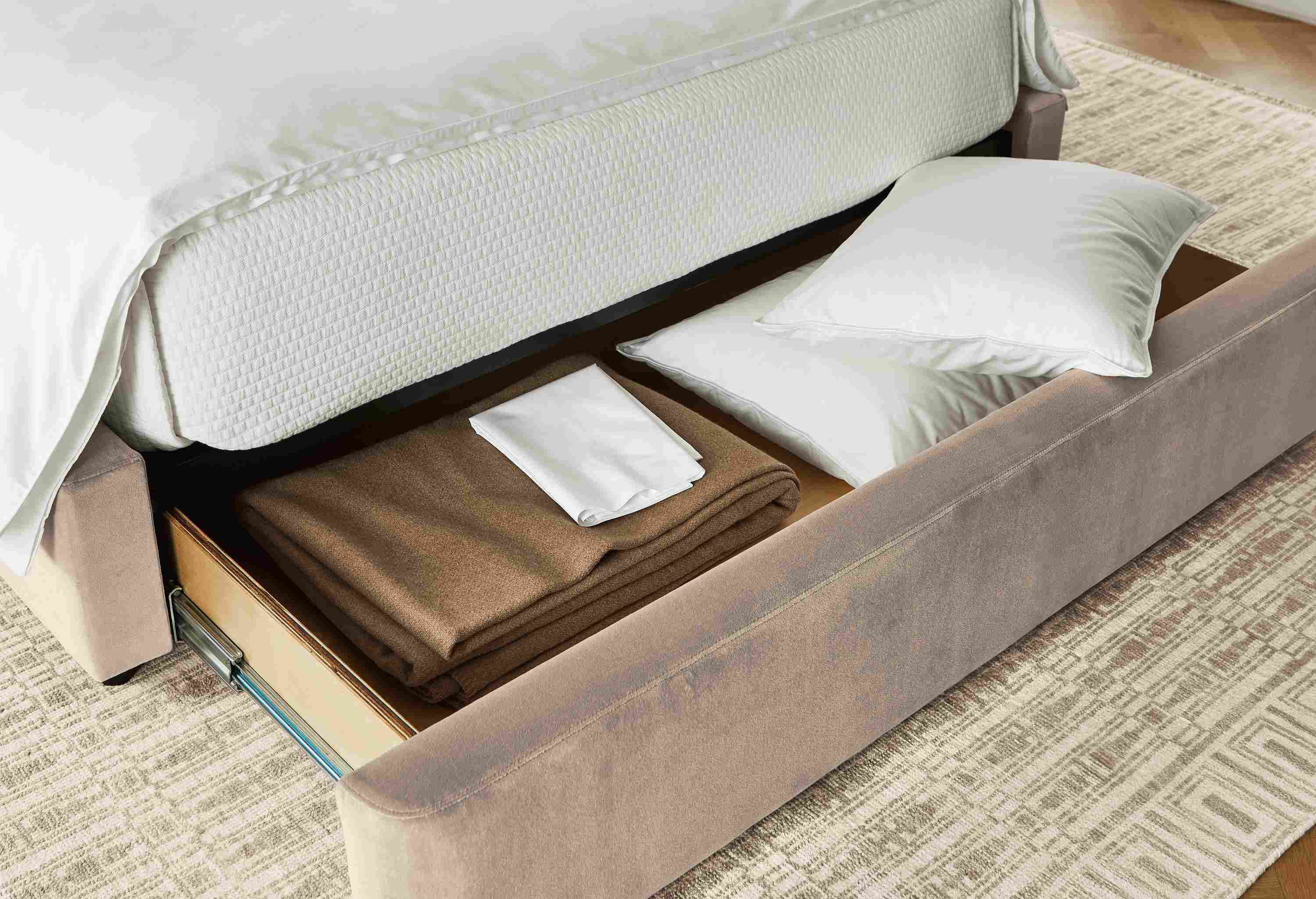 Close up of open drawer on Loxley queen storage bed in windsor asphalt and Tulum rug in taupe.