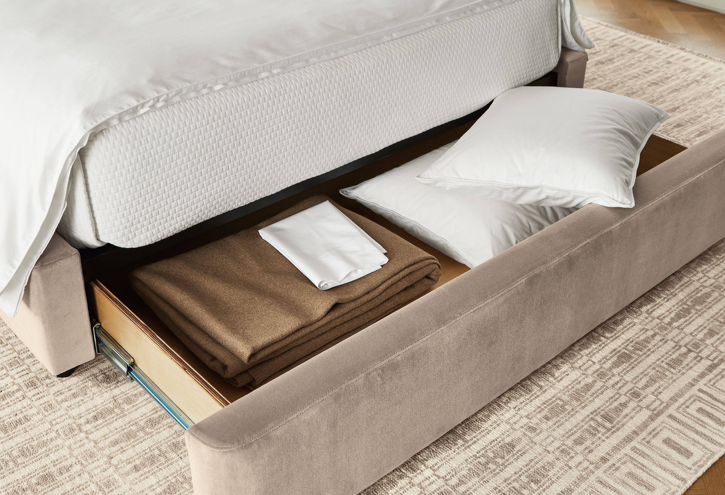 Close up of open drawer on Loxley queen storage bed in windsor asphalt and Tulum rug in taupe.