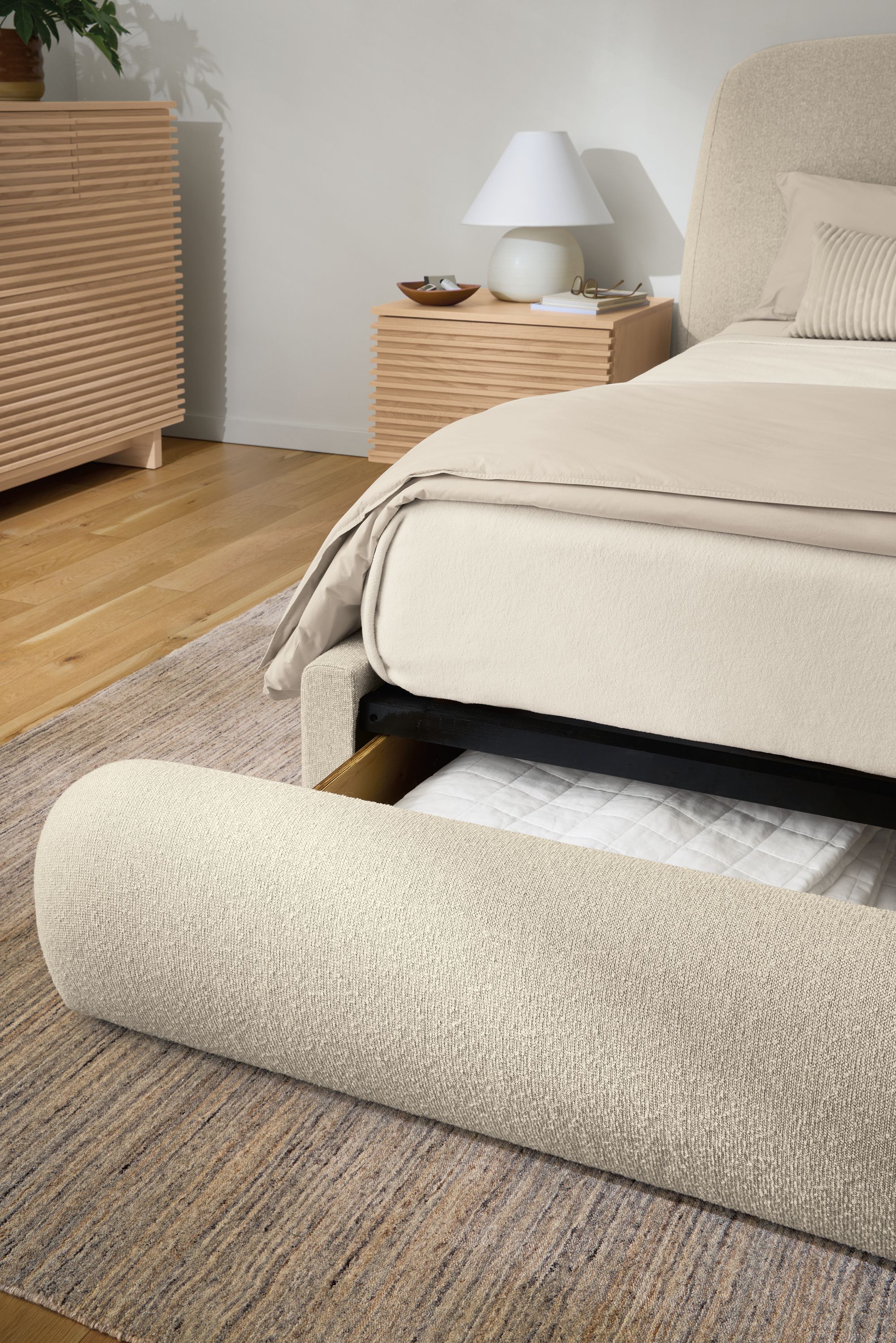 Bedroom with detail of a Luna queen storage bed in Conley Natural shown with storage drawer open.