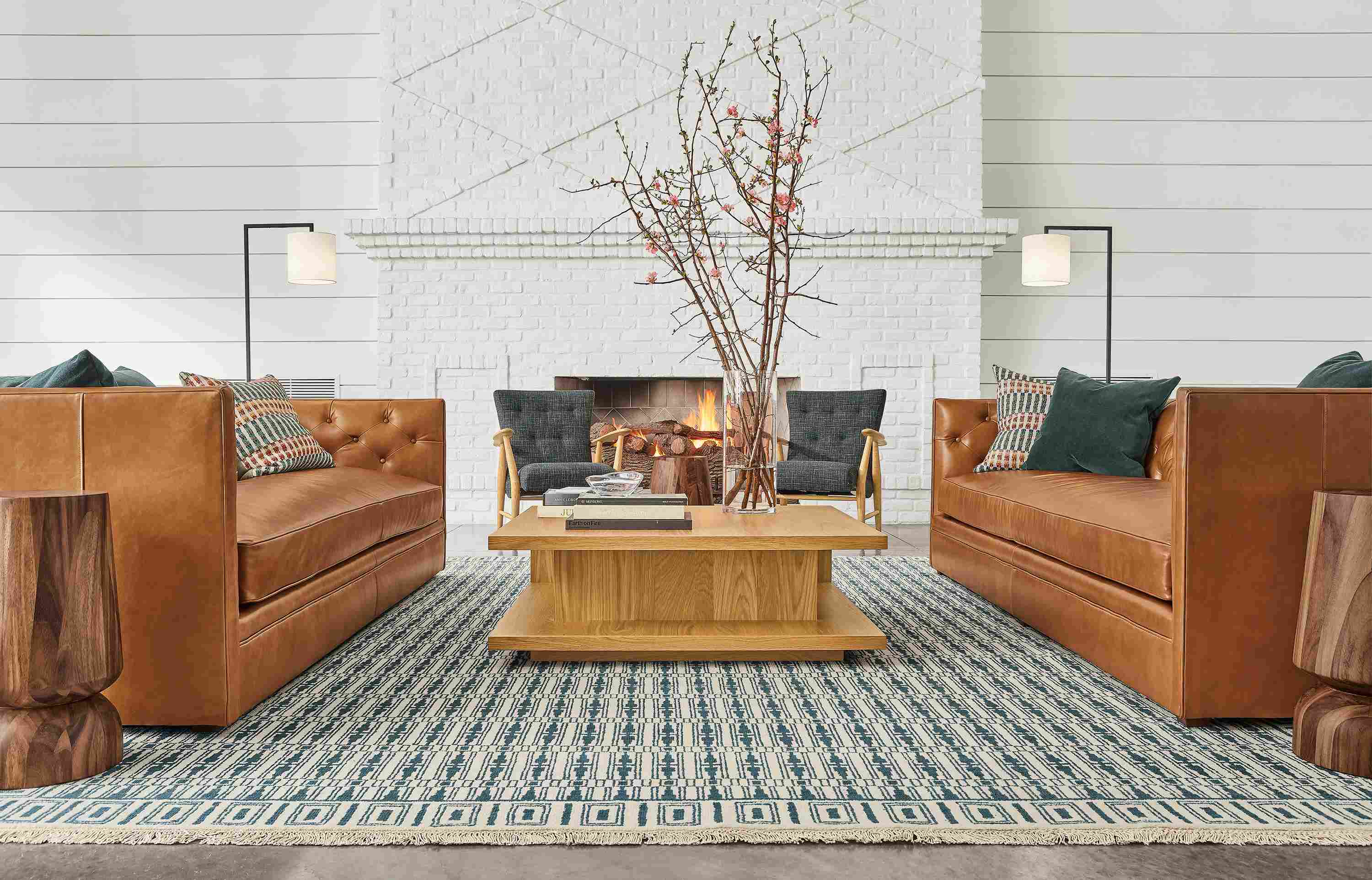 Detail of Macalester sofas in Portofino Cognac leather and Graham coffee table in white oak in lobby setting.