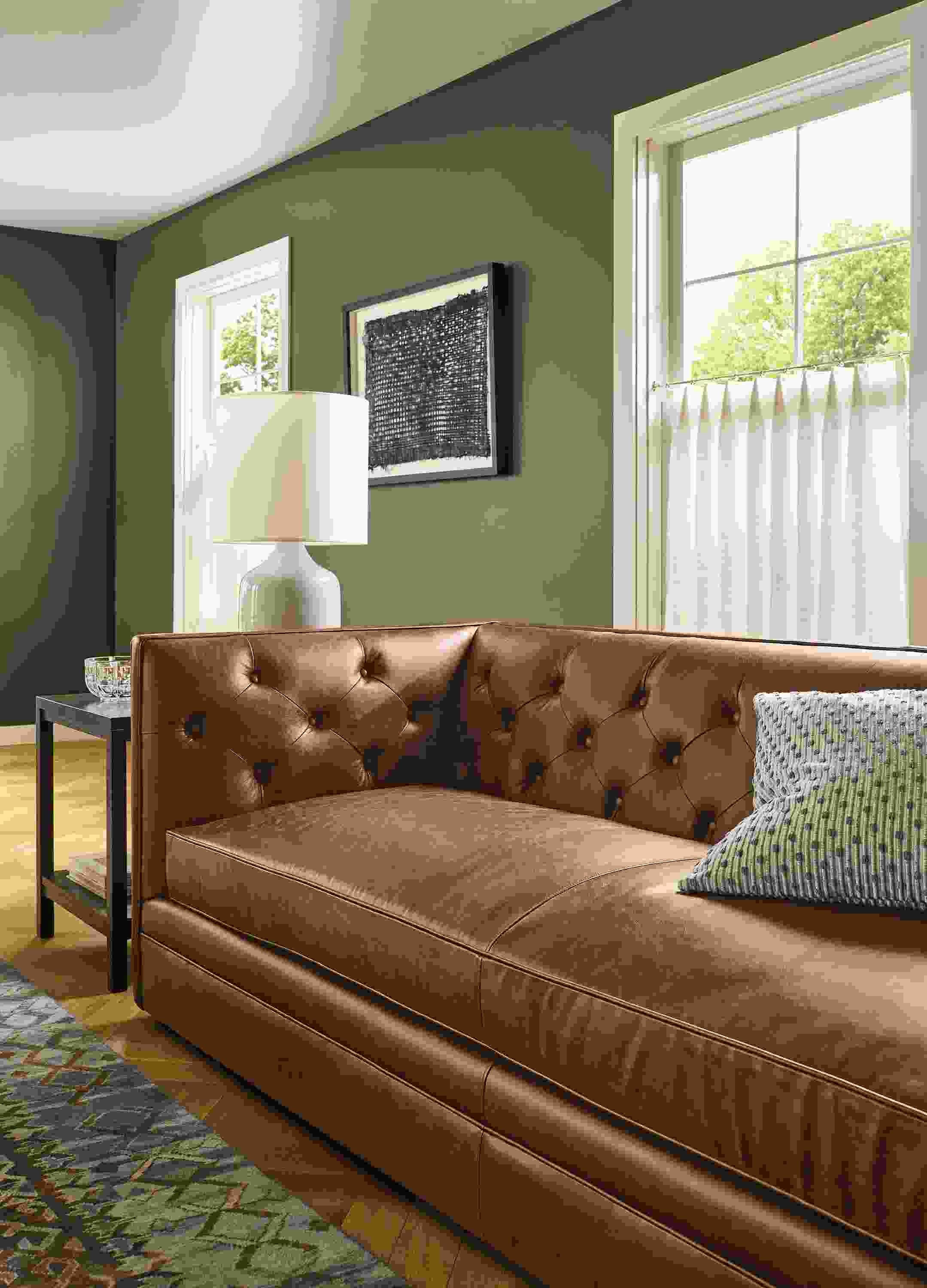 Detail of Macalester 90-wide sofa in Palermo Bourbon leather and Macy pillow in sage.