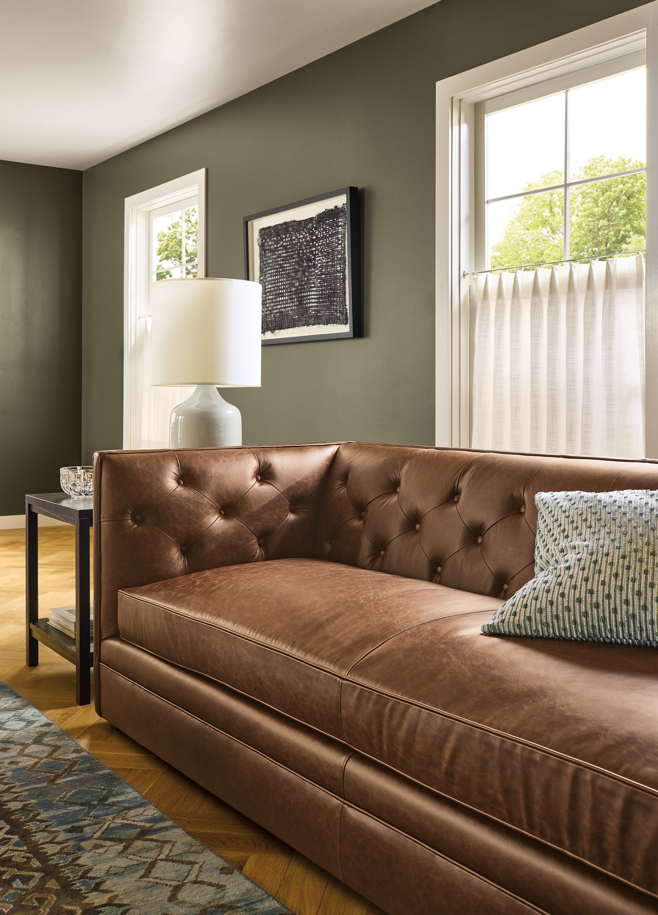 Detail of Macalester 90-wide sofa in Palermo Bourbon leather and Macy pillow in sage.