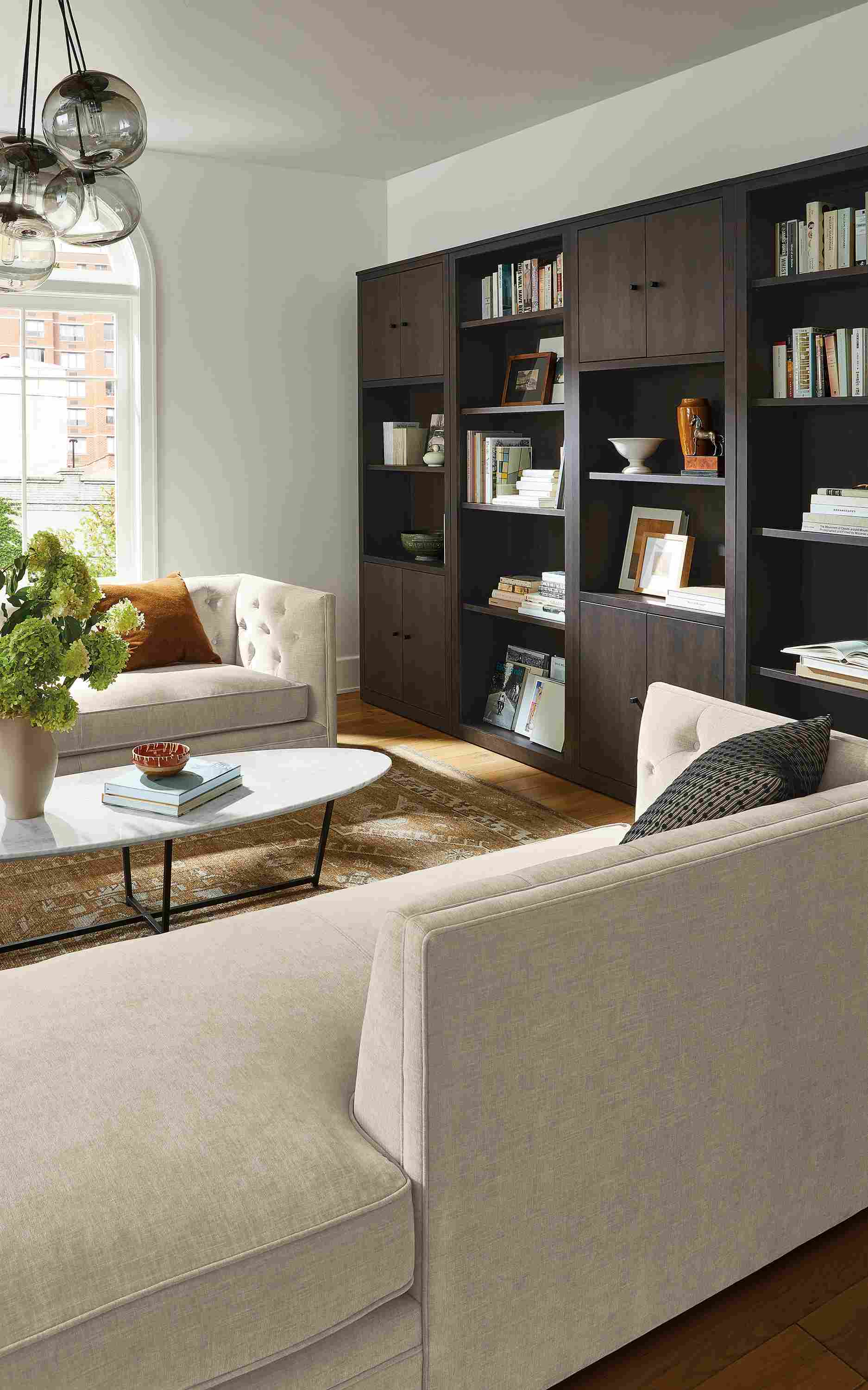 Living room with Macalester chaise and sofa in Mori oatmeal, Woodwind bookcases in charcoal.